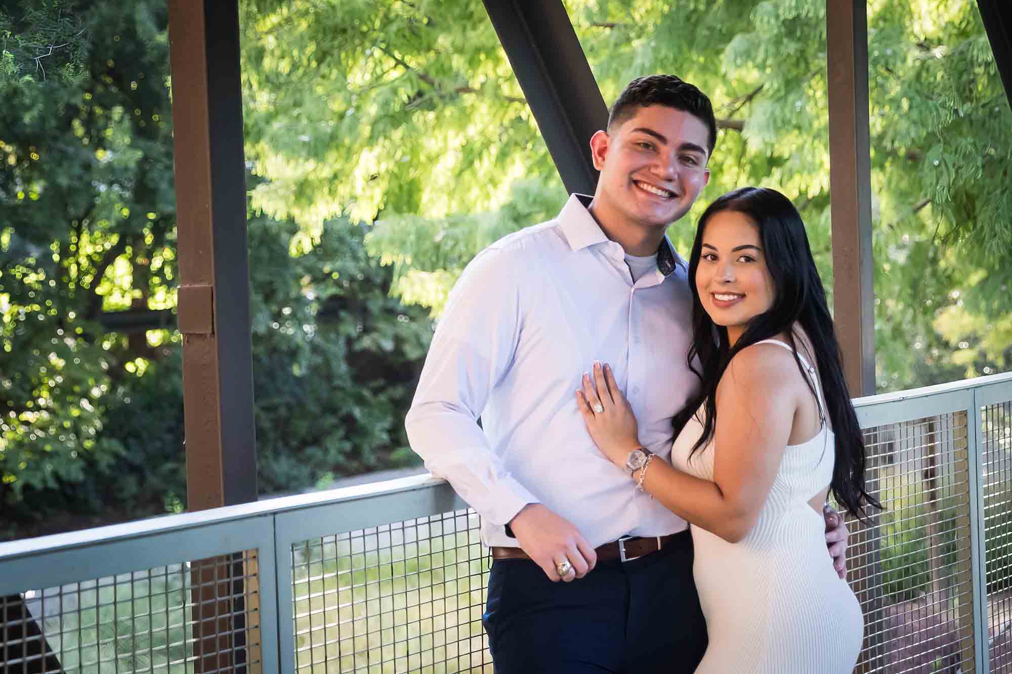 Couple hugging on covered bridge for an article on Pearl surprise proposal tips