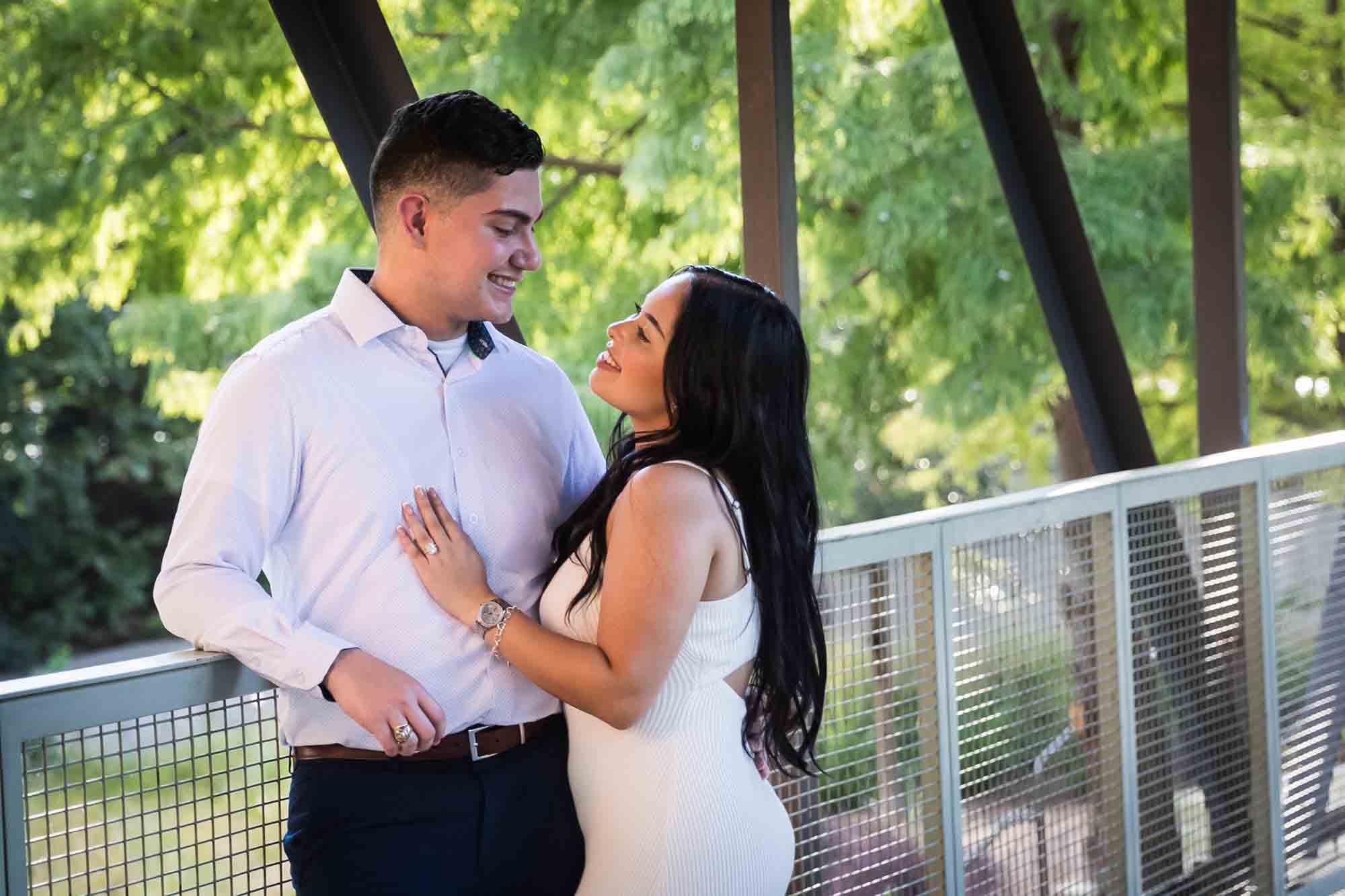 Couple hugging on covered bridge for an article on Pearl surprise proposal tips