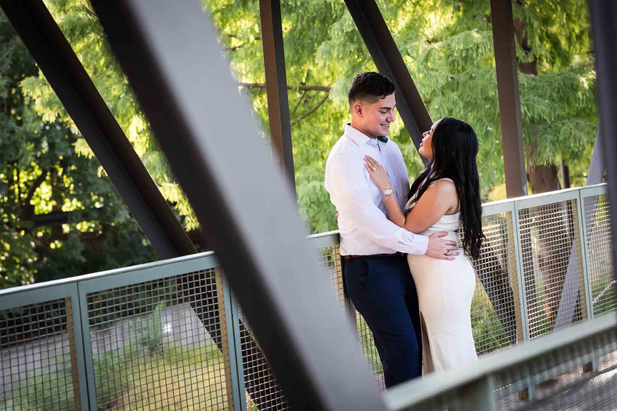 Couple hugging on covered bridge for an article on Pearl surprise proposal tips