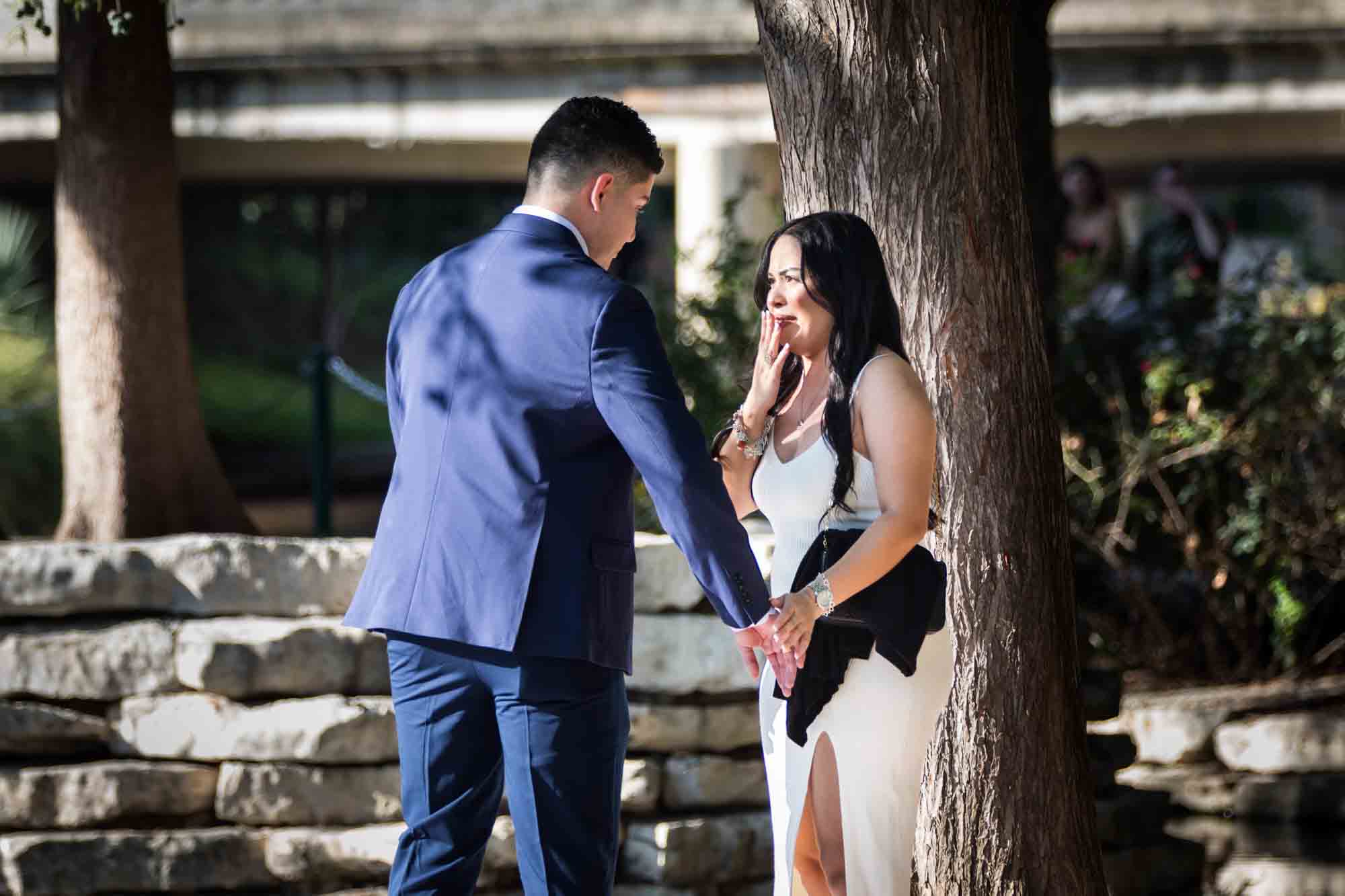 Man in blue suit proposing to woman at Pearl Springs after proposal for an article on Pearl surprise proposal tips