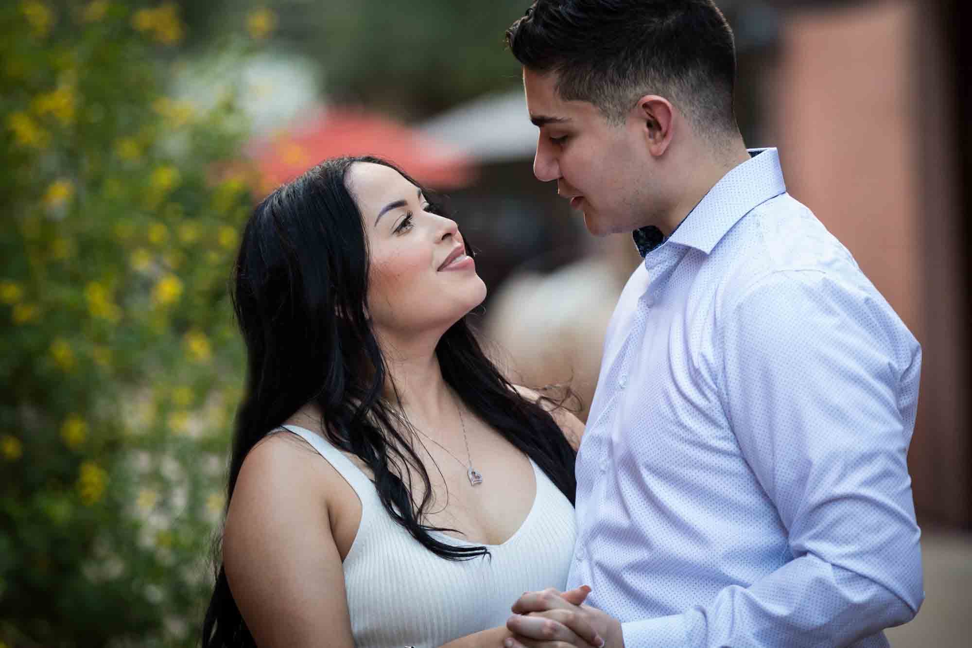 Couple dancing in front of bush with yellow flowers for an article on Pearl surprise proposal tips