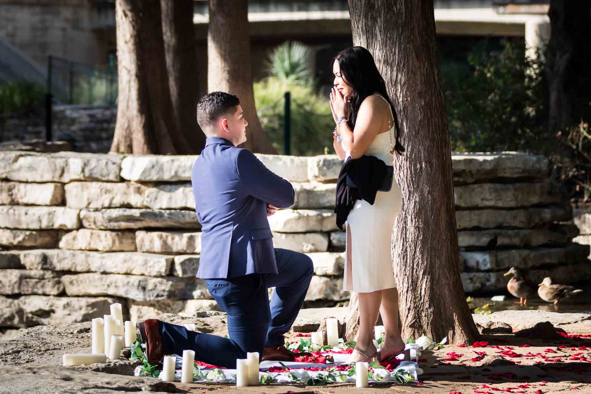 Man down on one knee proposing to woman at Pearl Springs after proposal for an article on Pearl surprise proposal tips