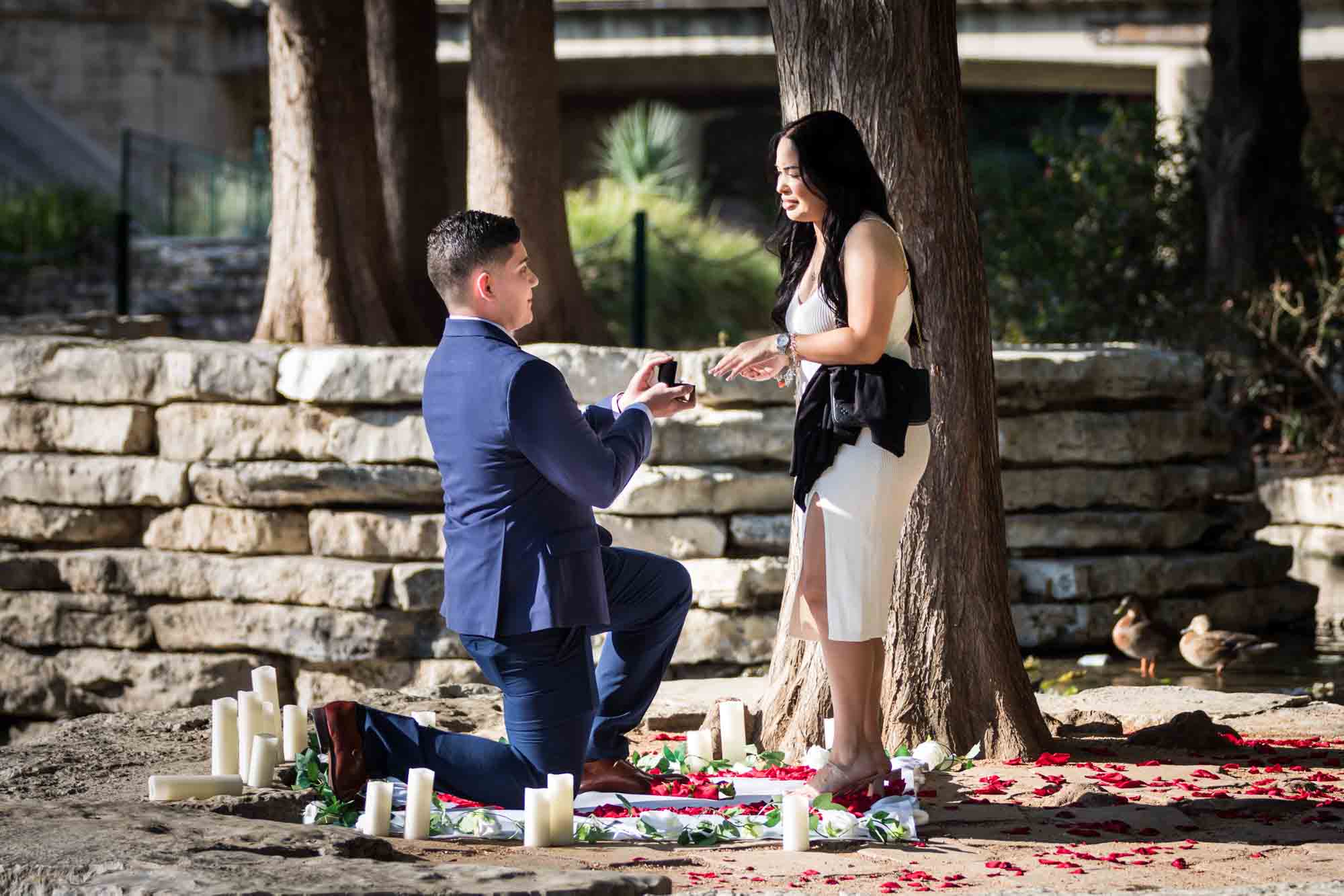 Man down on one knee proposing to woman at Pearl Springs after proposal for an article on Pearl surprise proposal tips