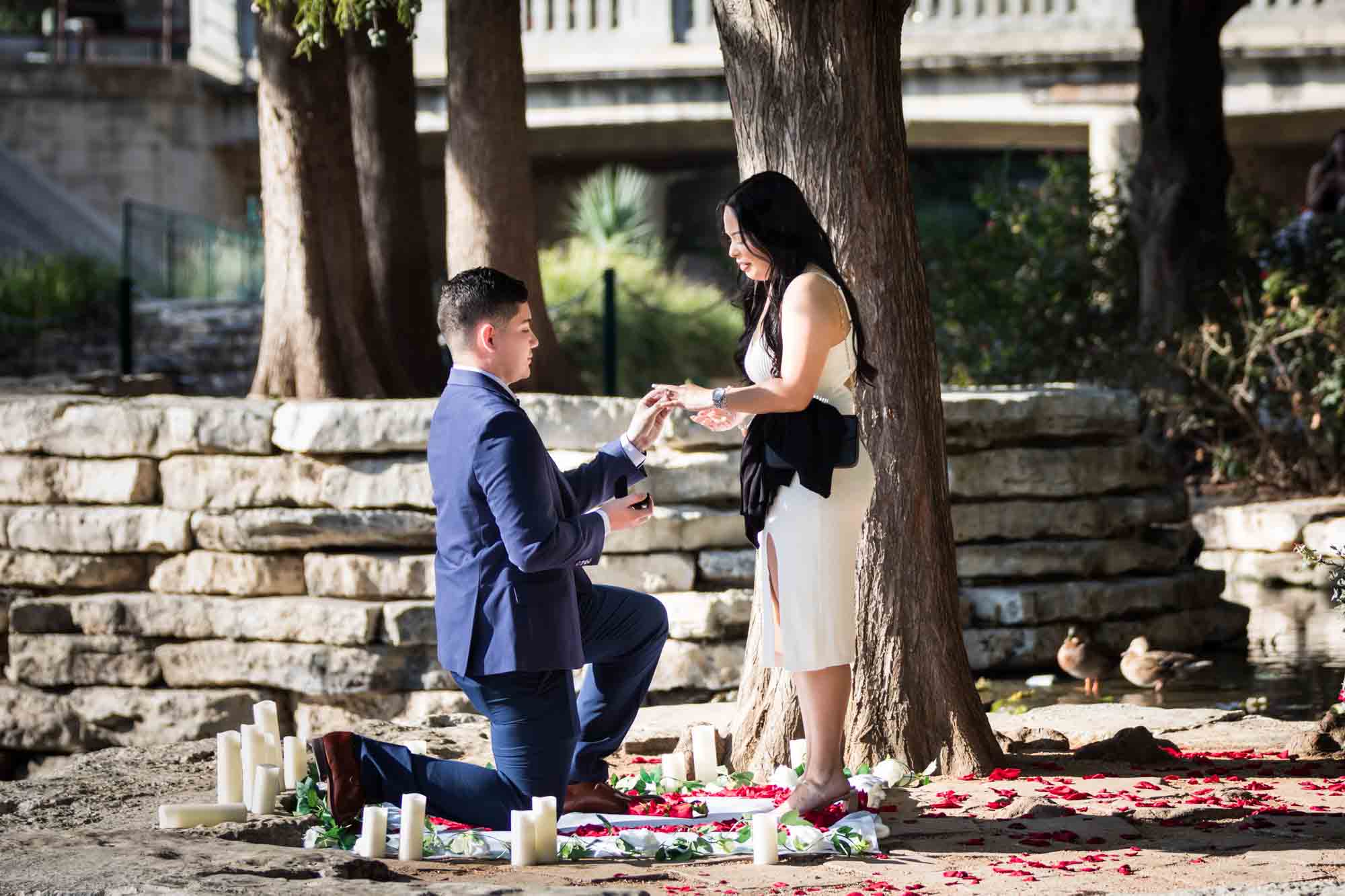 Man down on one knee proposing to woman at Pearl Springs after proposal for an article on Pearl surprise proposal tips