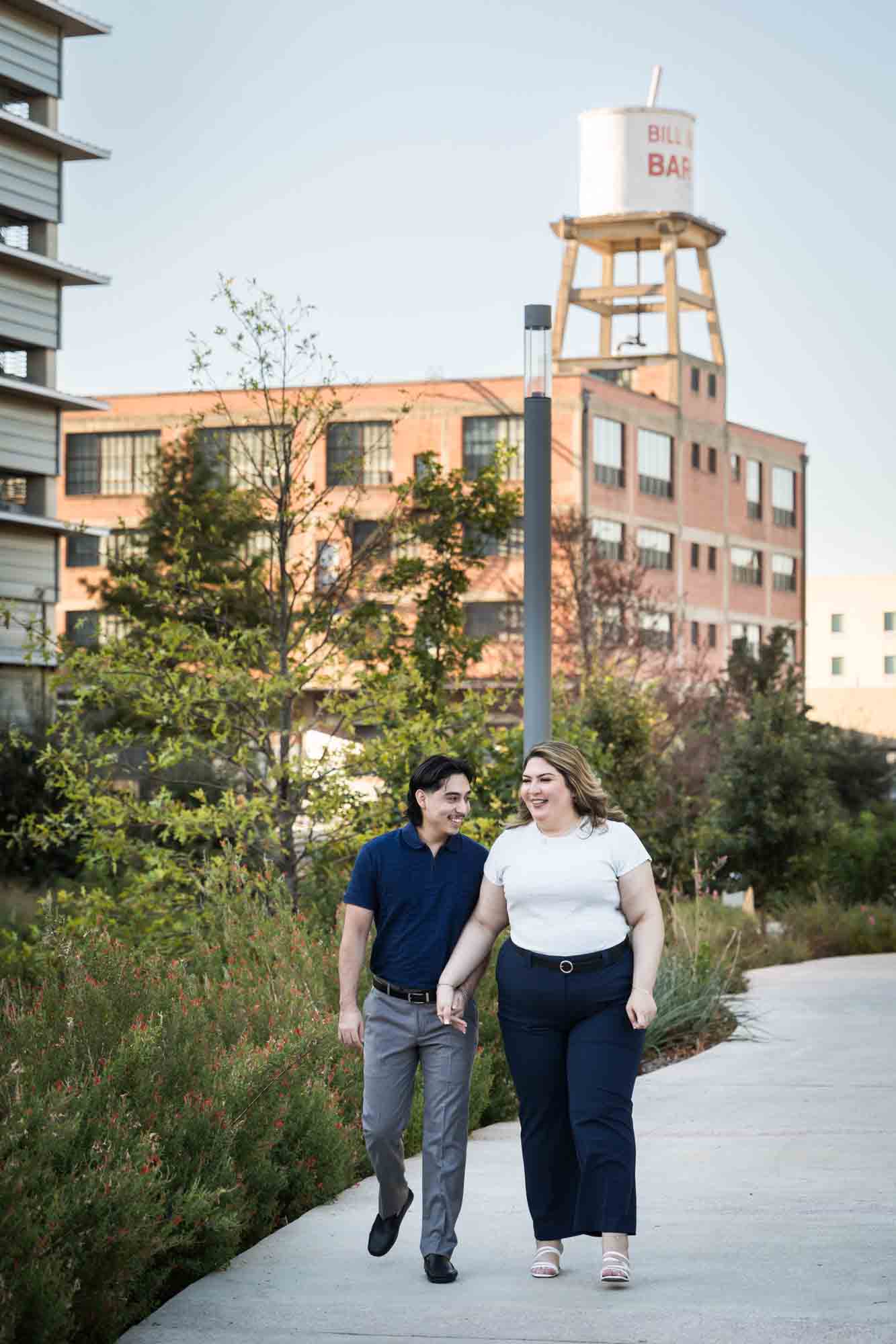 Couple walking along San Pedro Creek pathway during a downtown San Antonio photo shoot