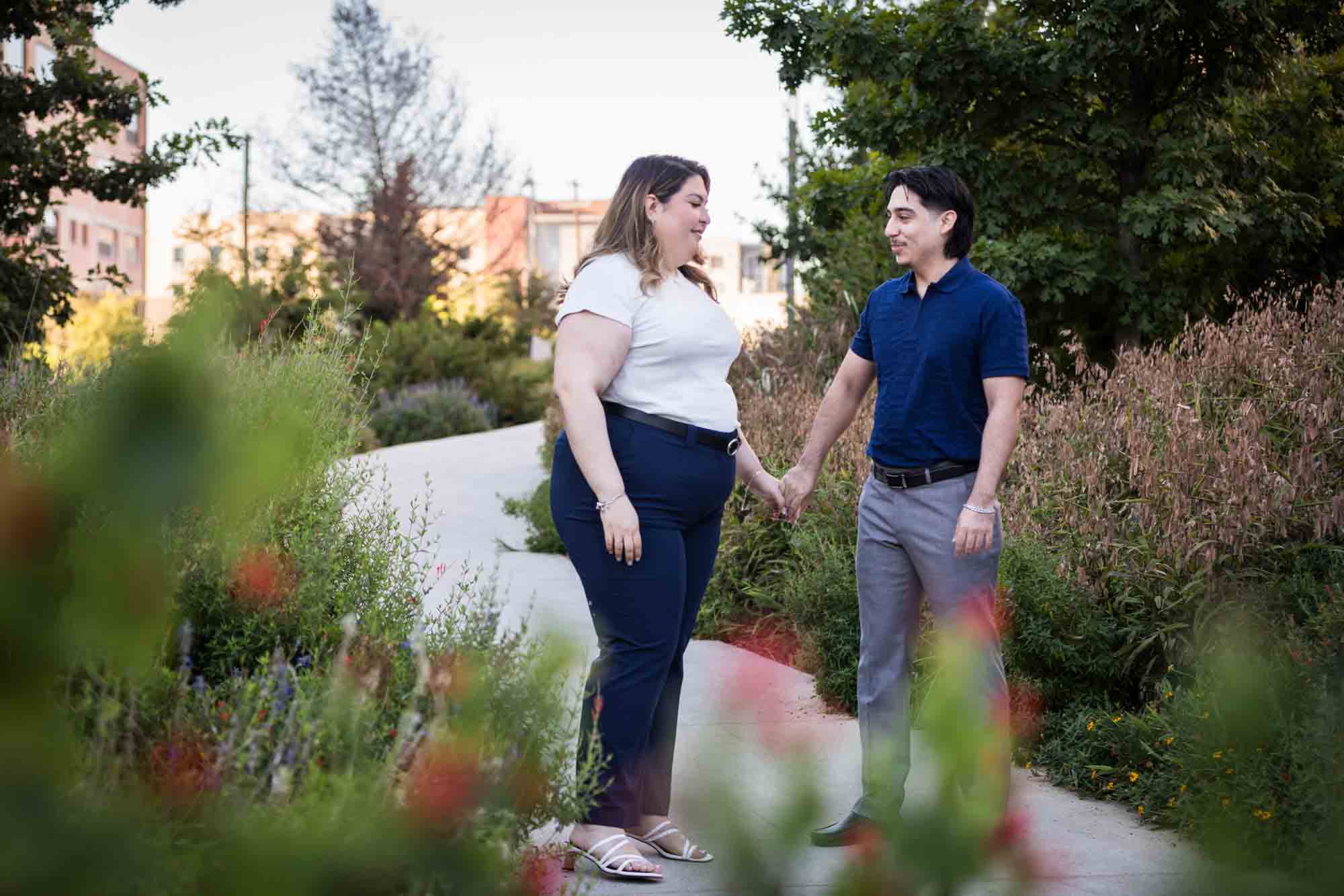 Couple holding hands on San Pedro Creek pathway during a downtown San Antonio photo shoot