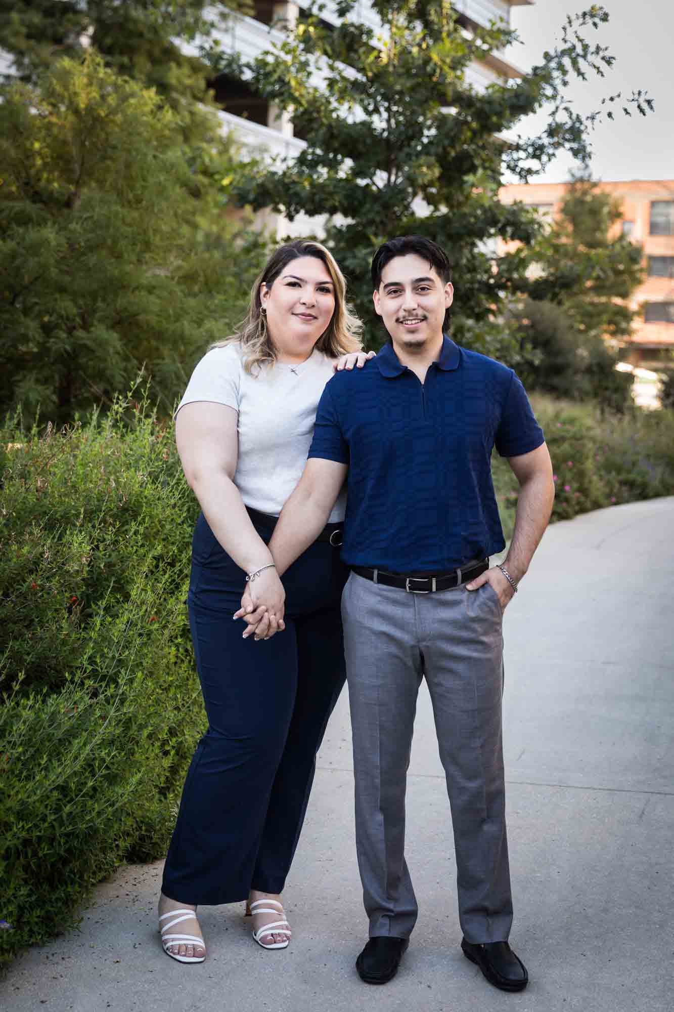 Couple holding hands on San Pedro Creek pathway during a downtown San Antonio photo shoot