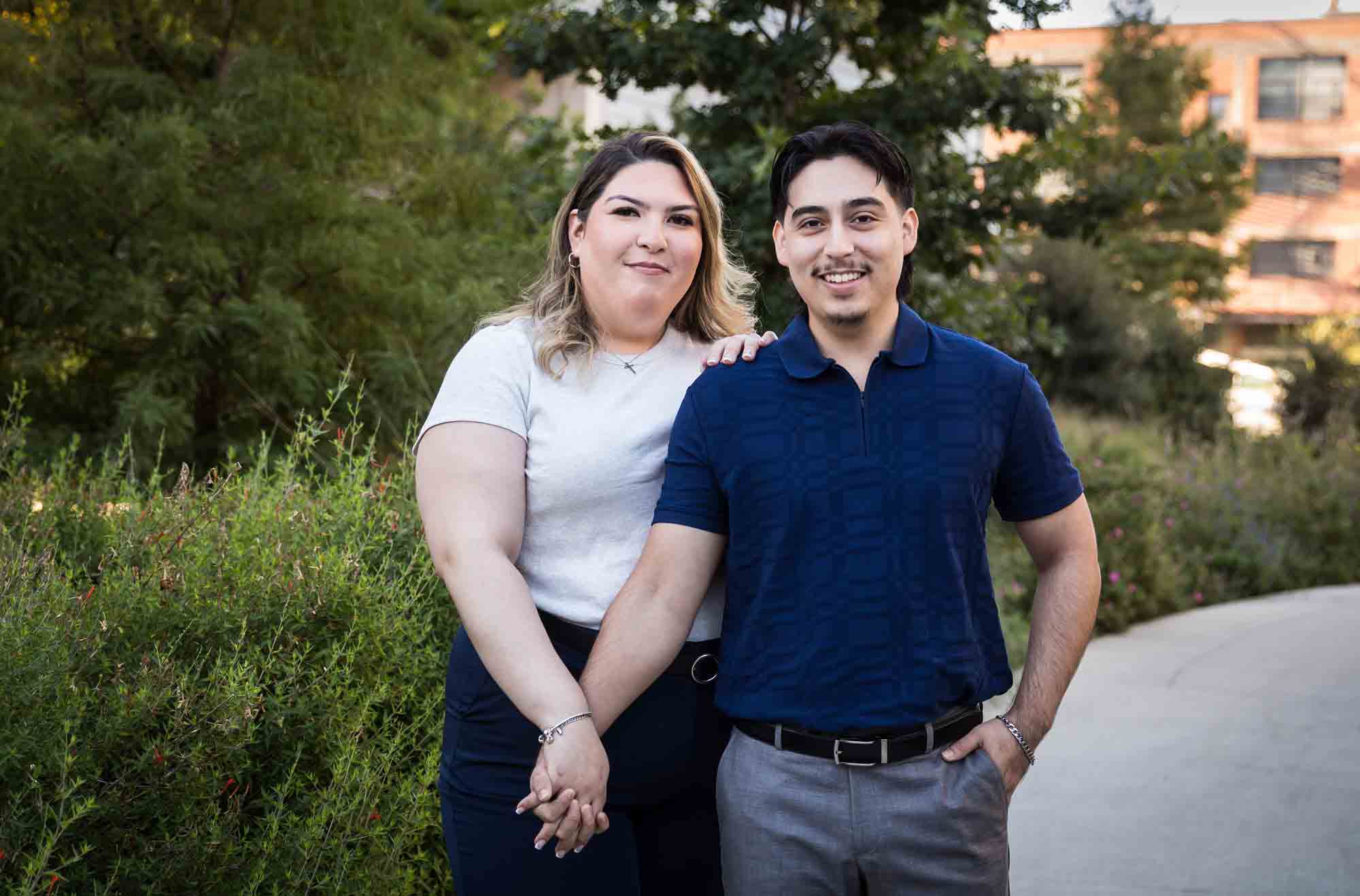 Couple holding hands on San Pedro Creek pathway during a downtown San Antonio photo shoot