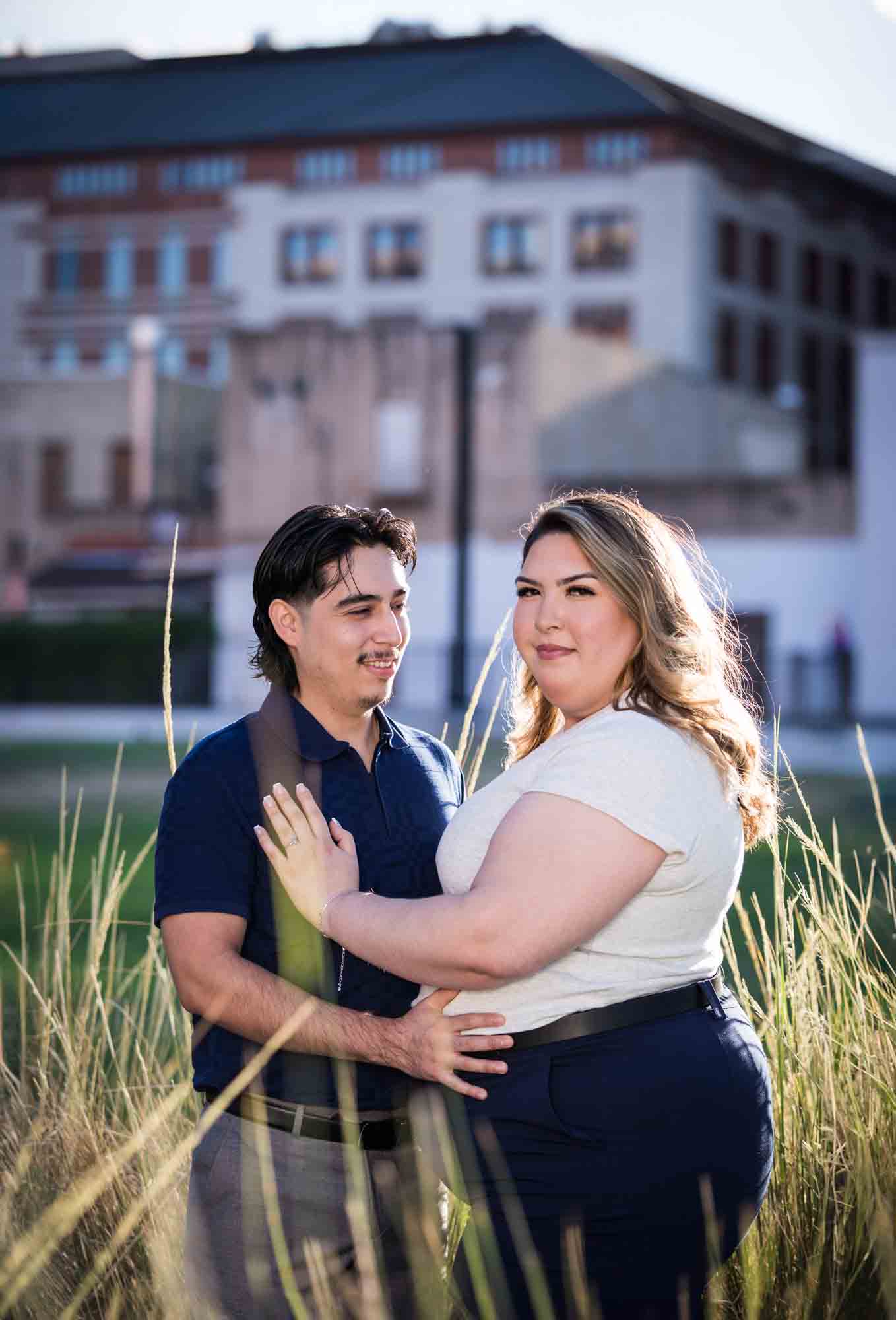 Couple touching in front of long bushes during a downtown San Antonio photo shoot