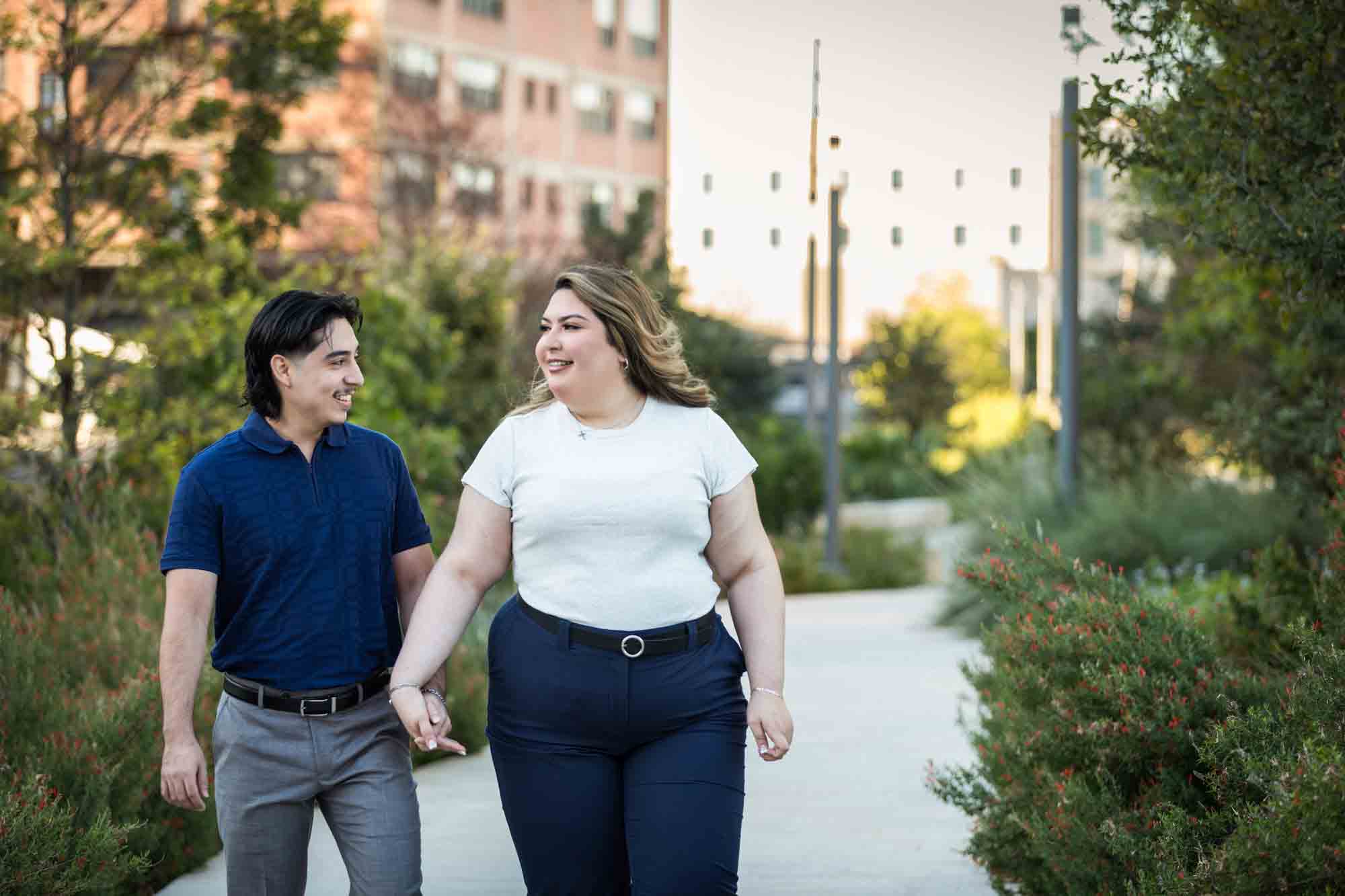 Couple walking along San Pedro Creek pathway during a downtown San Antonio photo shoot