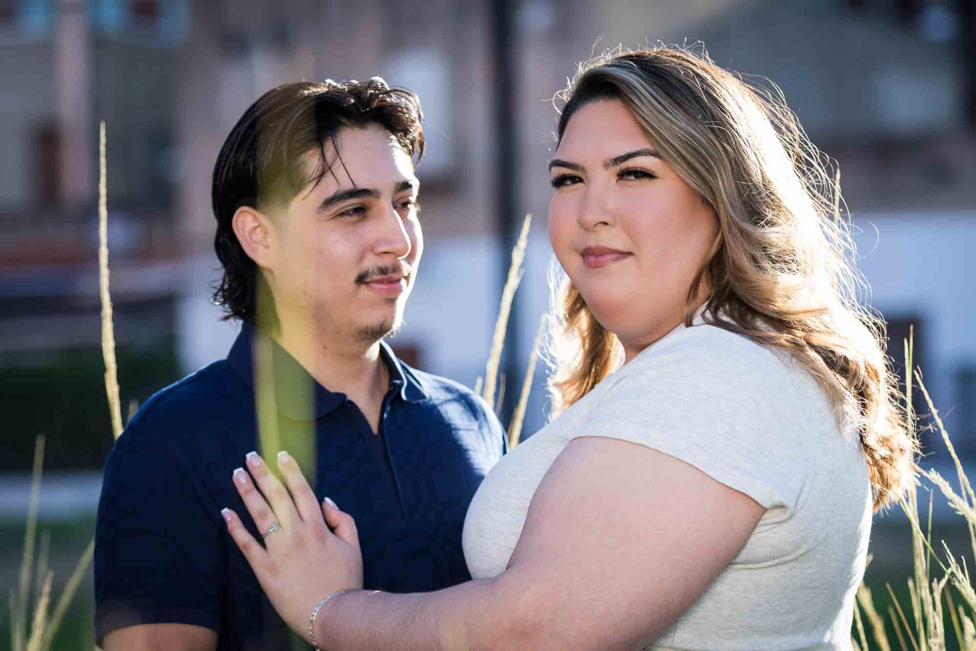 Couple touching in front of long bushes during a downtown San Antonio photo shoot