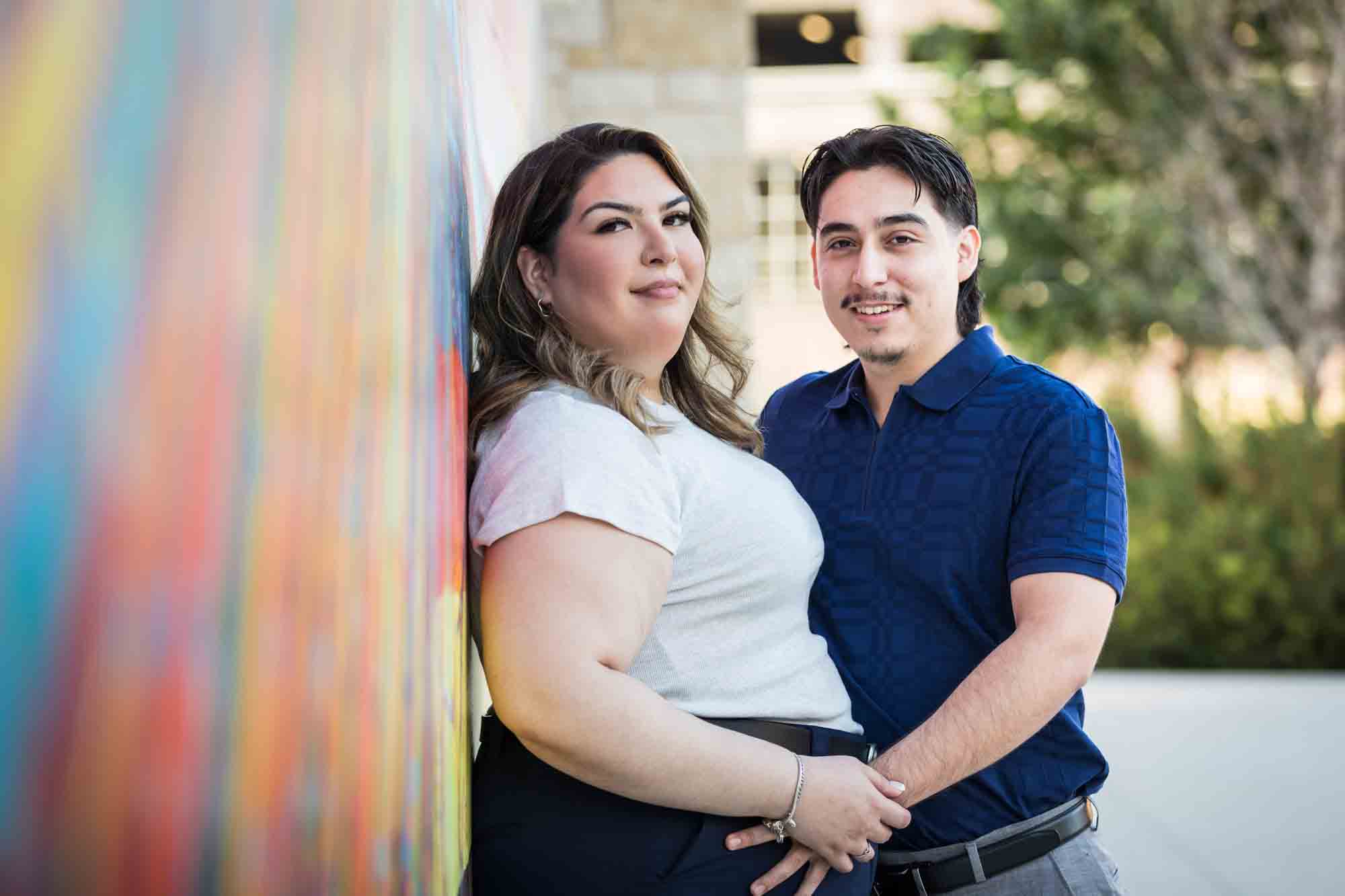 Couple standing against a colorful mural during a downtown San Antonio photo shoot