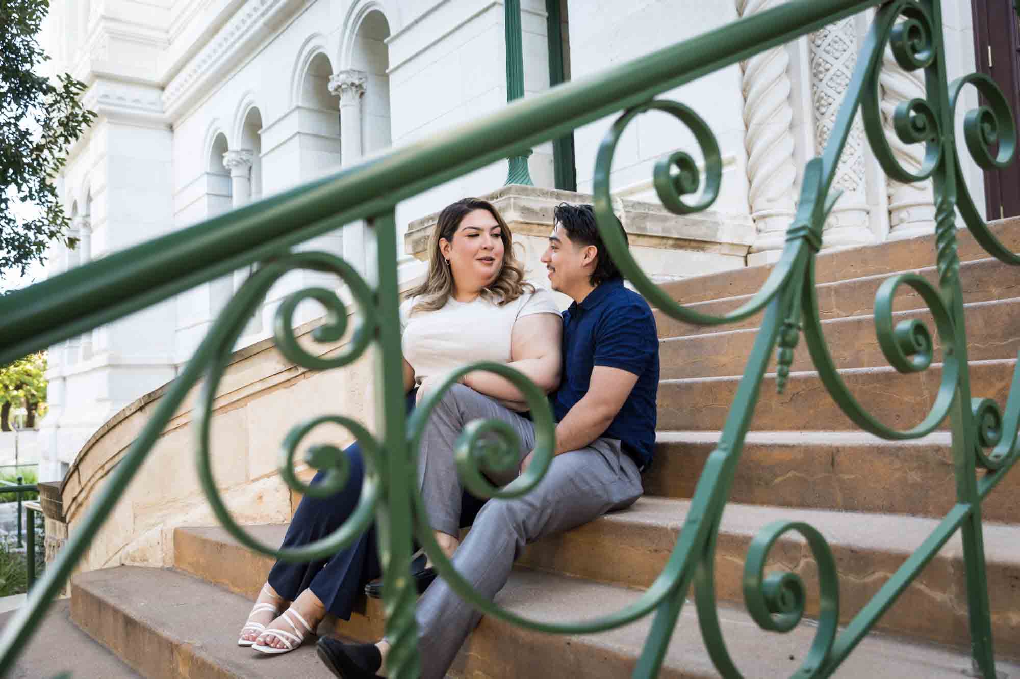 Couple sitting on back staircase of City Hall during a downtown San Antonio photo shoot