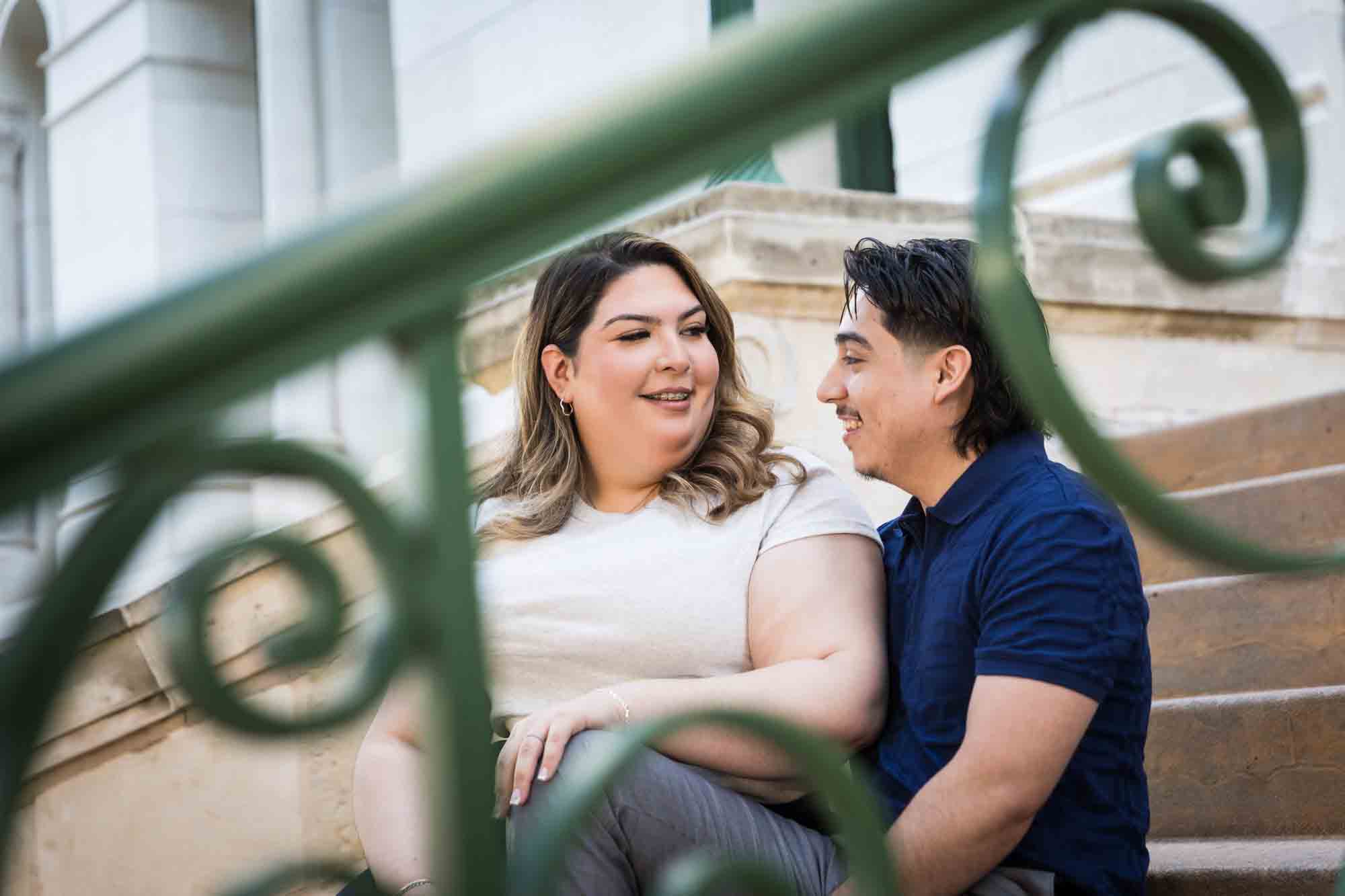 Couple sitting on back staircase of City Hall during a downtown San Antonio photo shoot