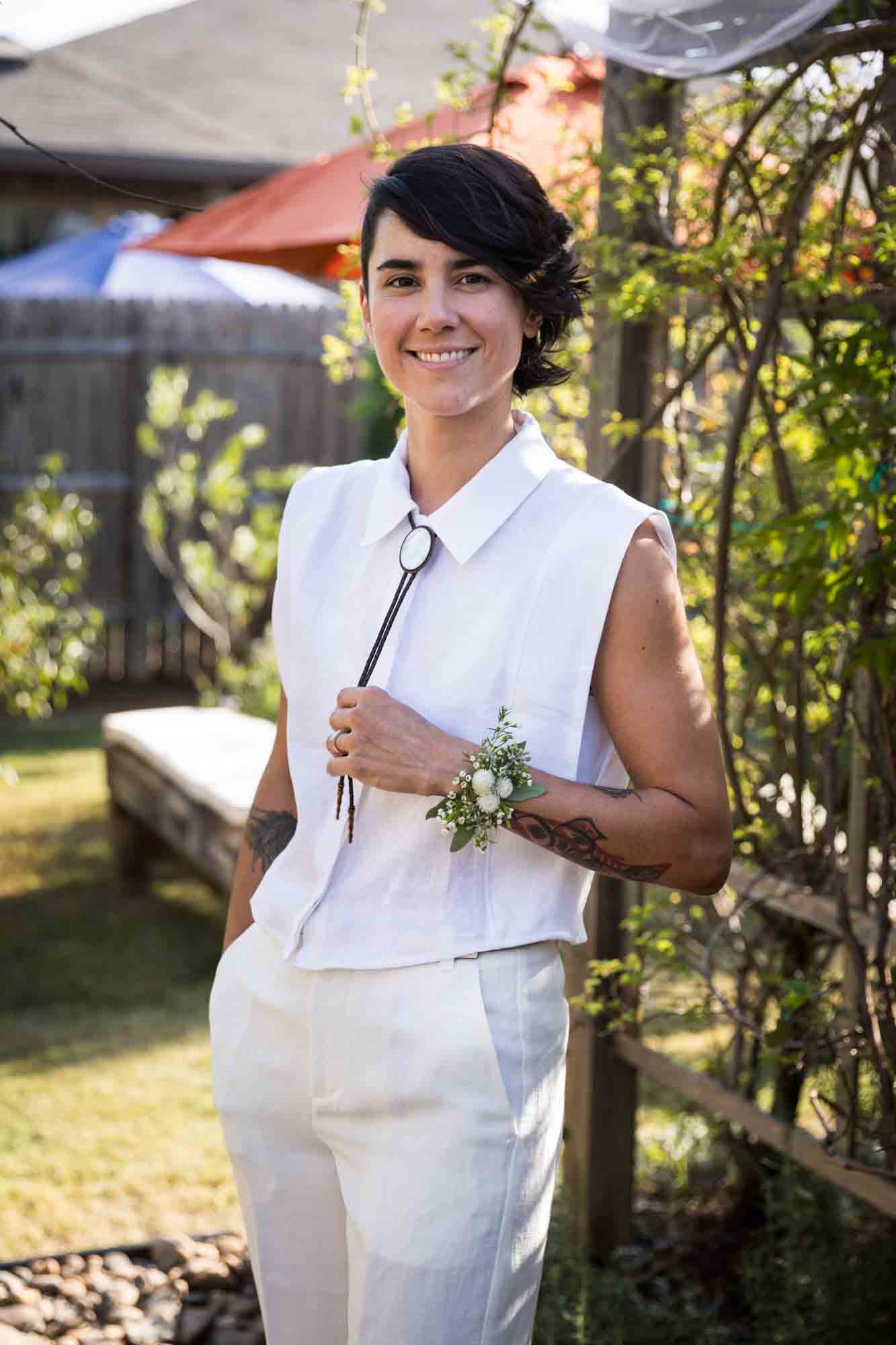 Bride wearing white and lariat in front of plants at a Boerne backyard wedding