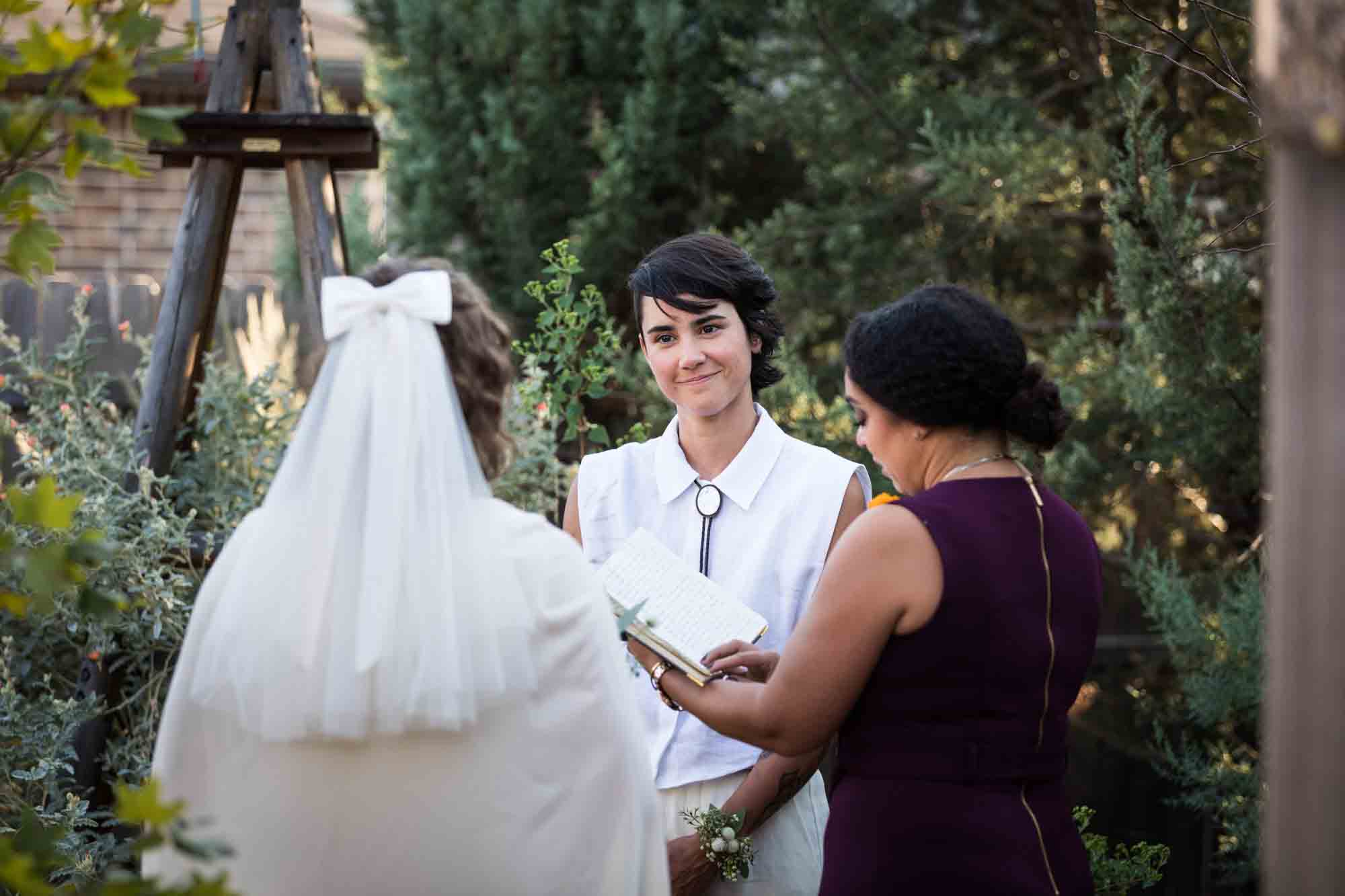 Officiant speaking in front of two brides at a Boerne backyard wedding