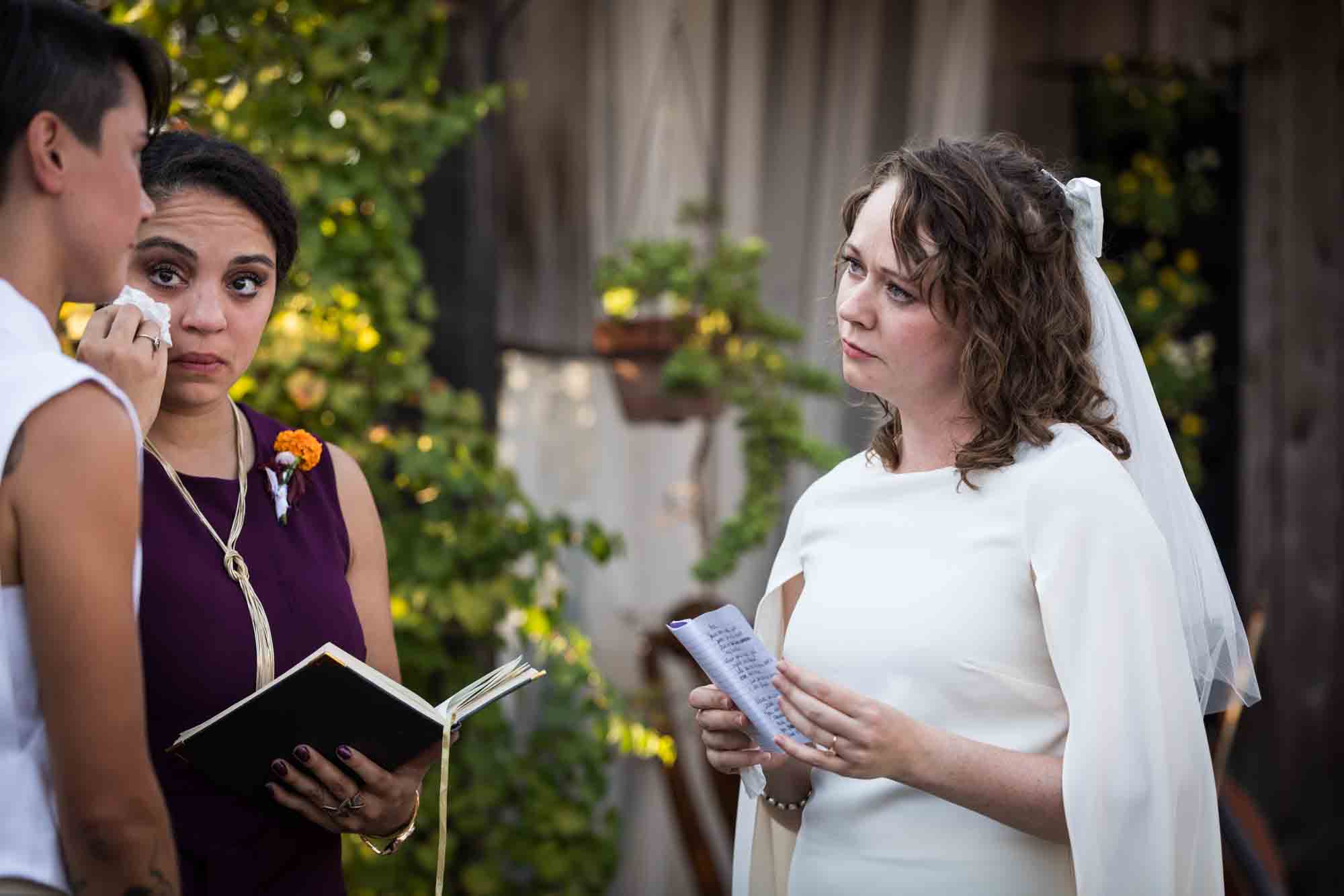 Bride wearing white dress and holding booklet at a Boerne backyard wedding