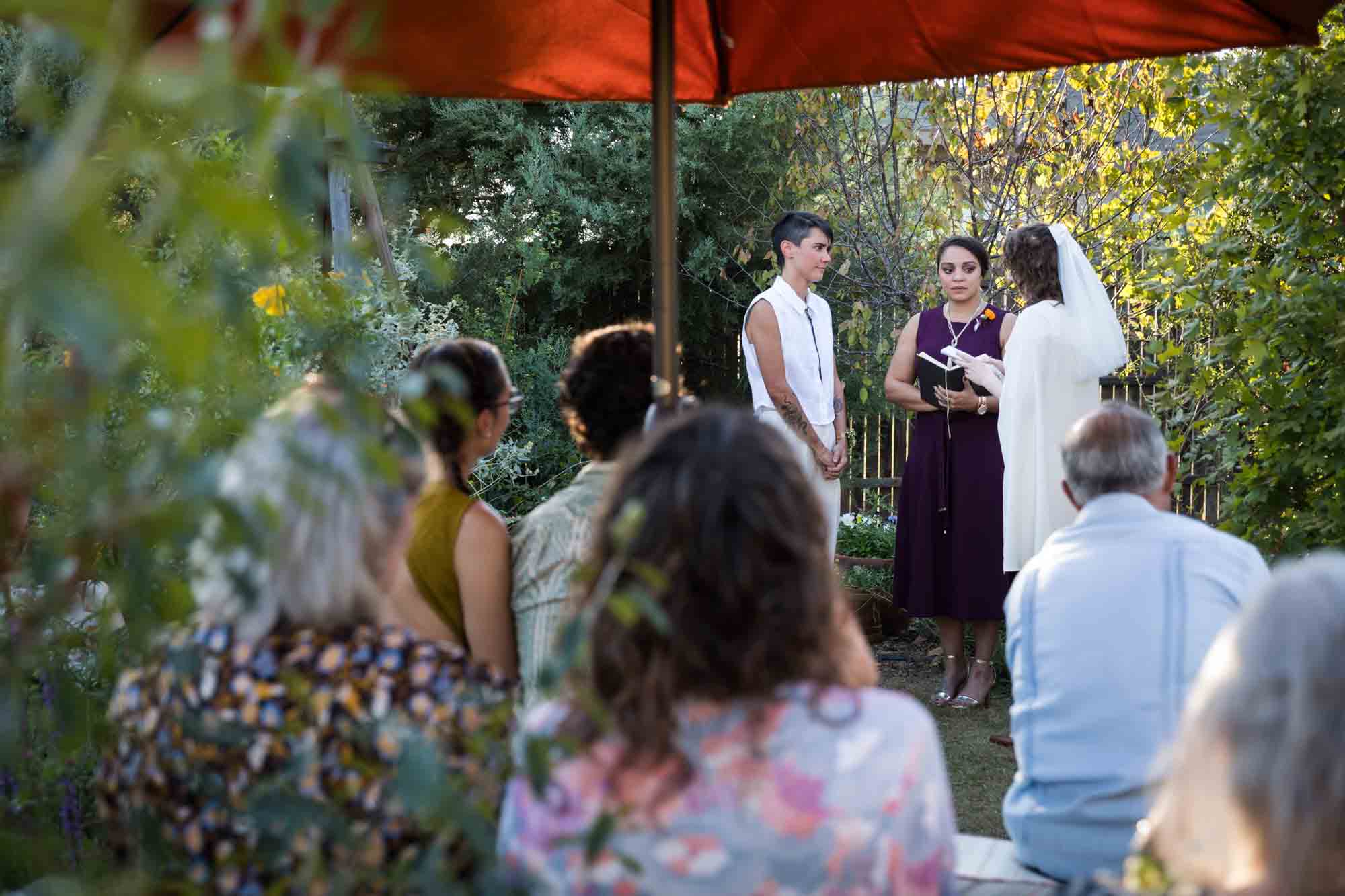 Two brides exchanging vows in front of guests at a Boerne backyard wedding