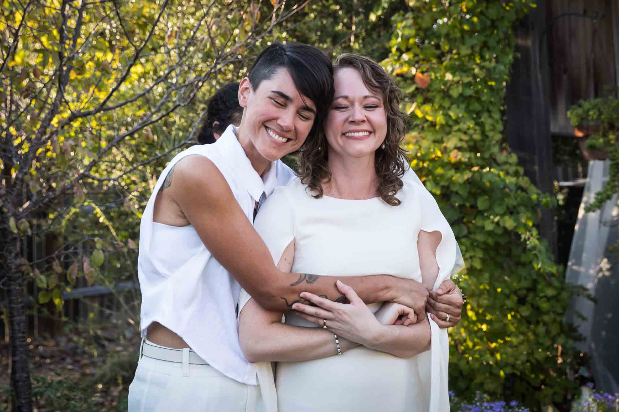 Two brides hugging after ceremony at a Boerne backyard wedding