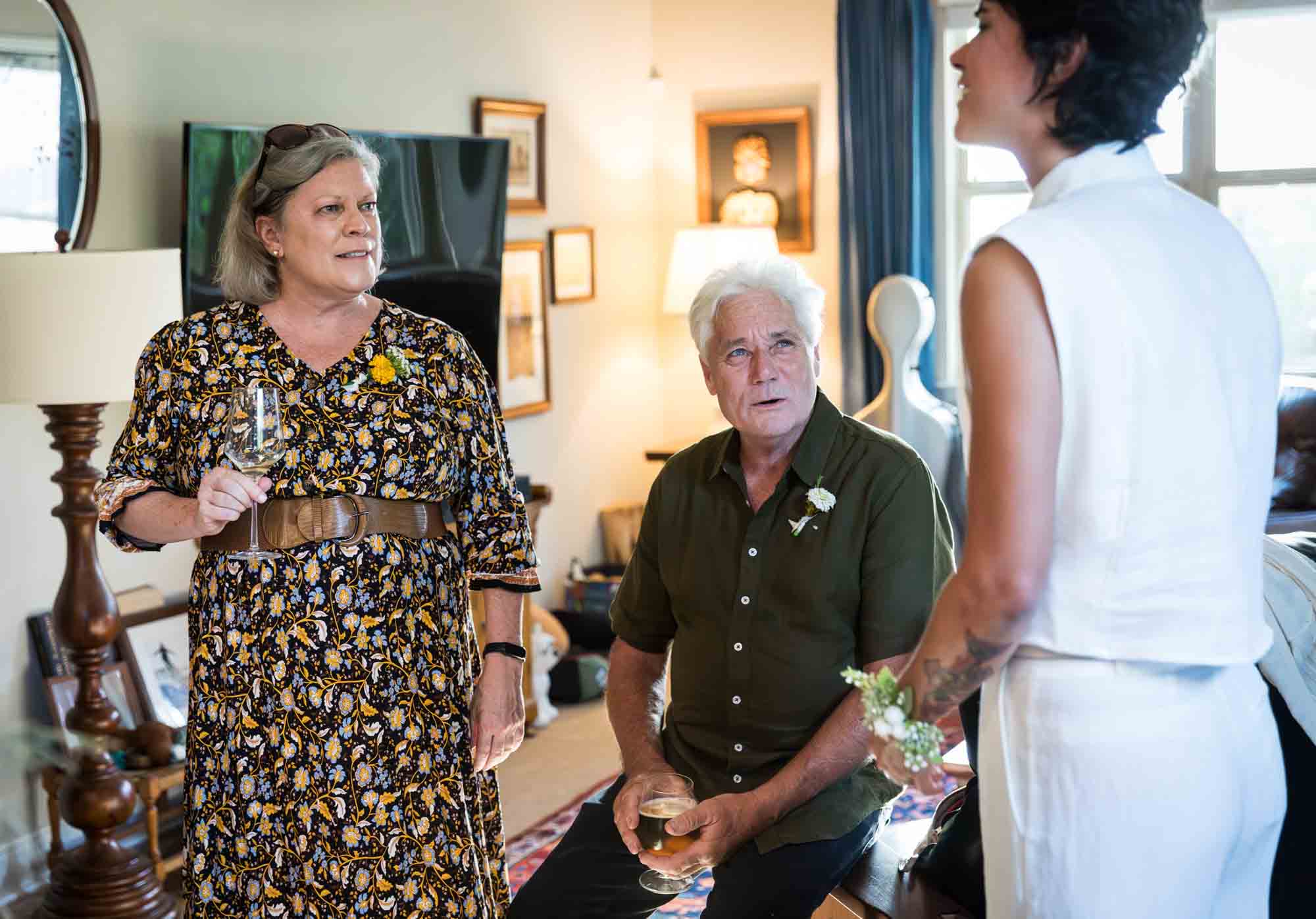 Guests drinking wine and enjoying reception in a home