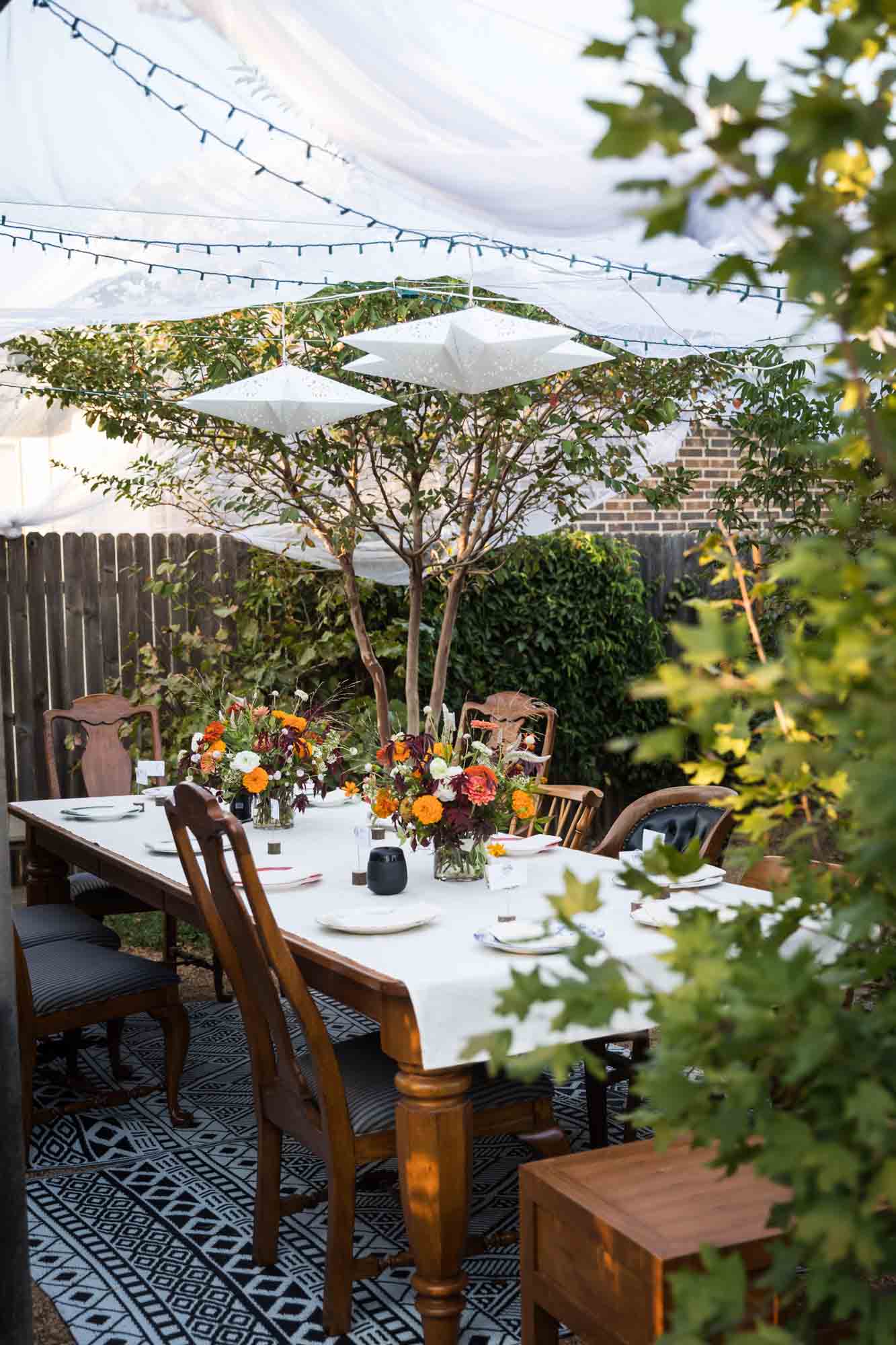 Table outside set with white tablecloth and beautiful flower bouquets