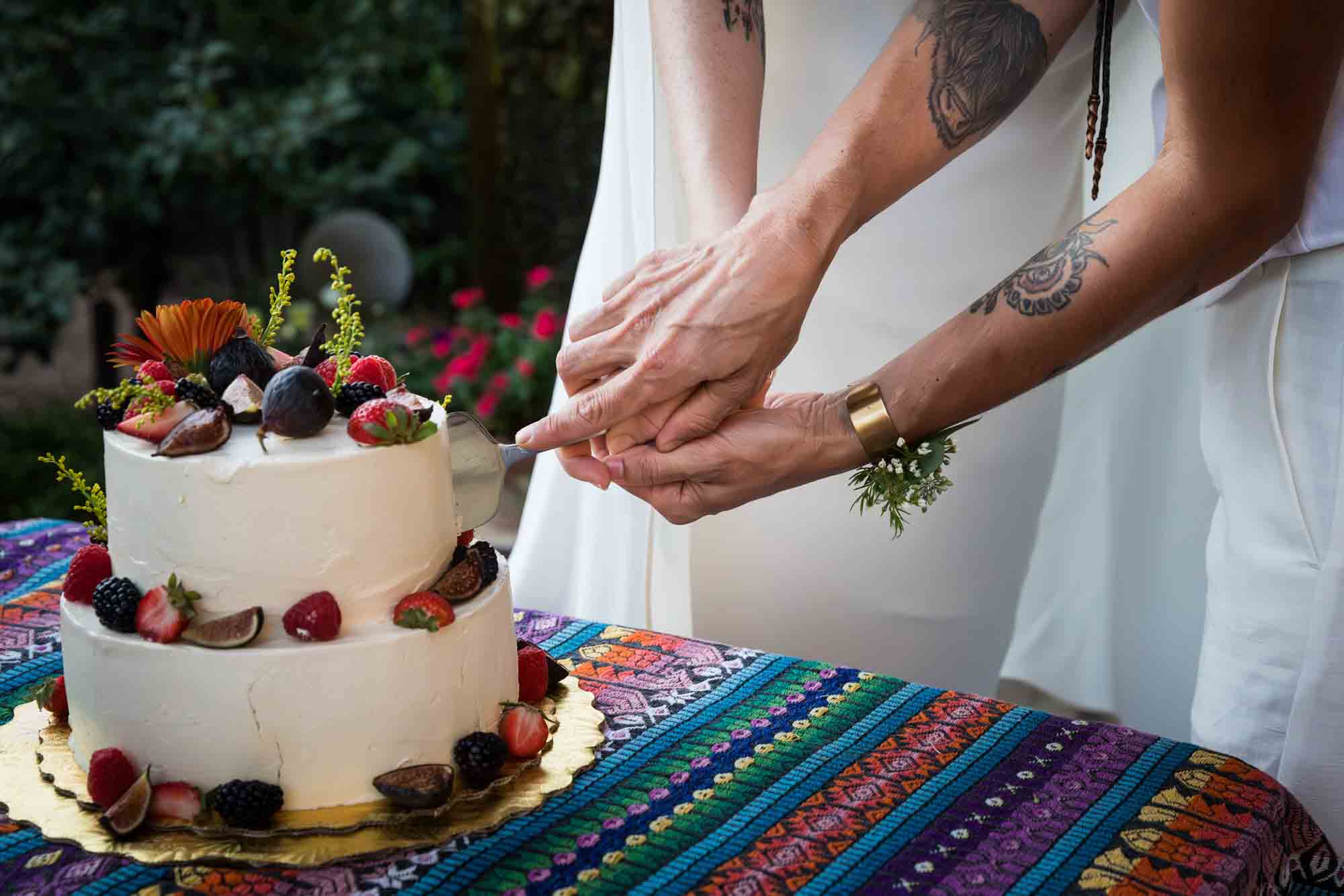 Close up of two women cutting a wedding cake together