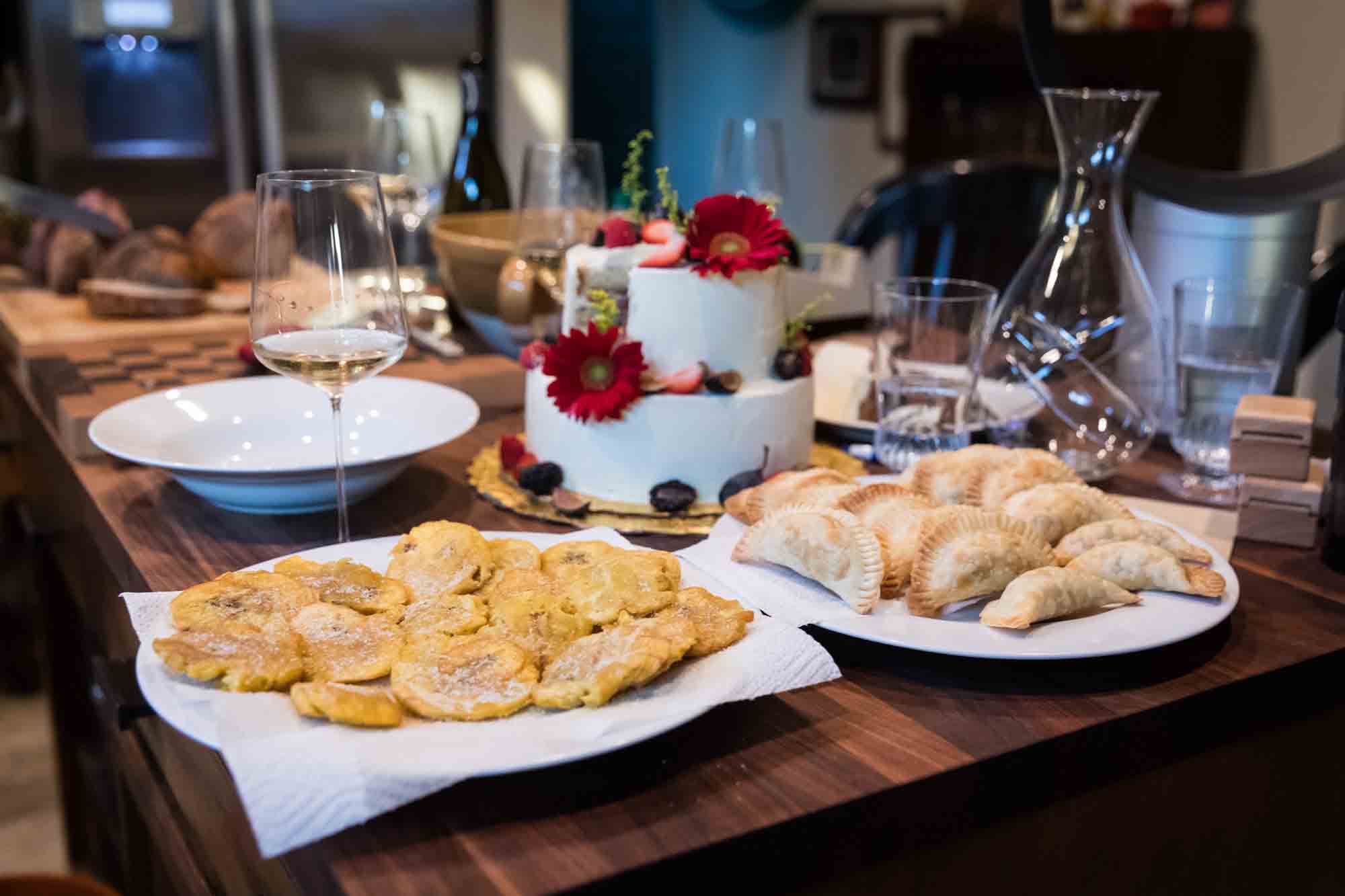 Plates of food in a kitchen including empanadas and tostones