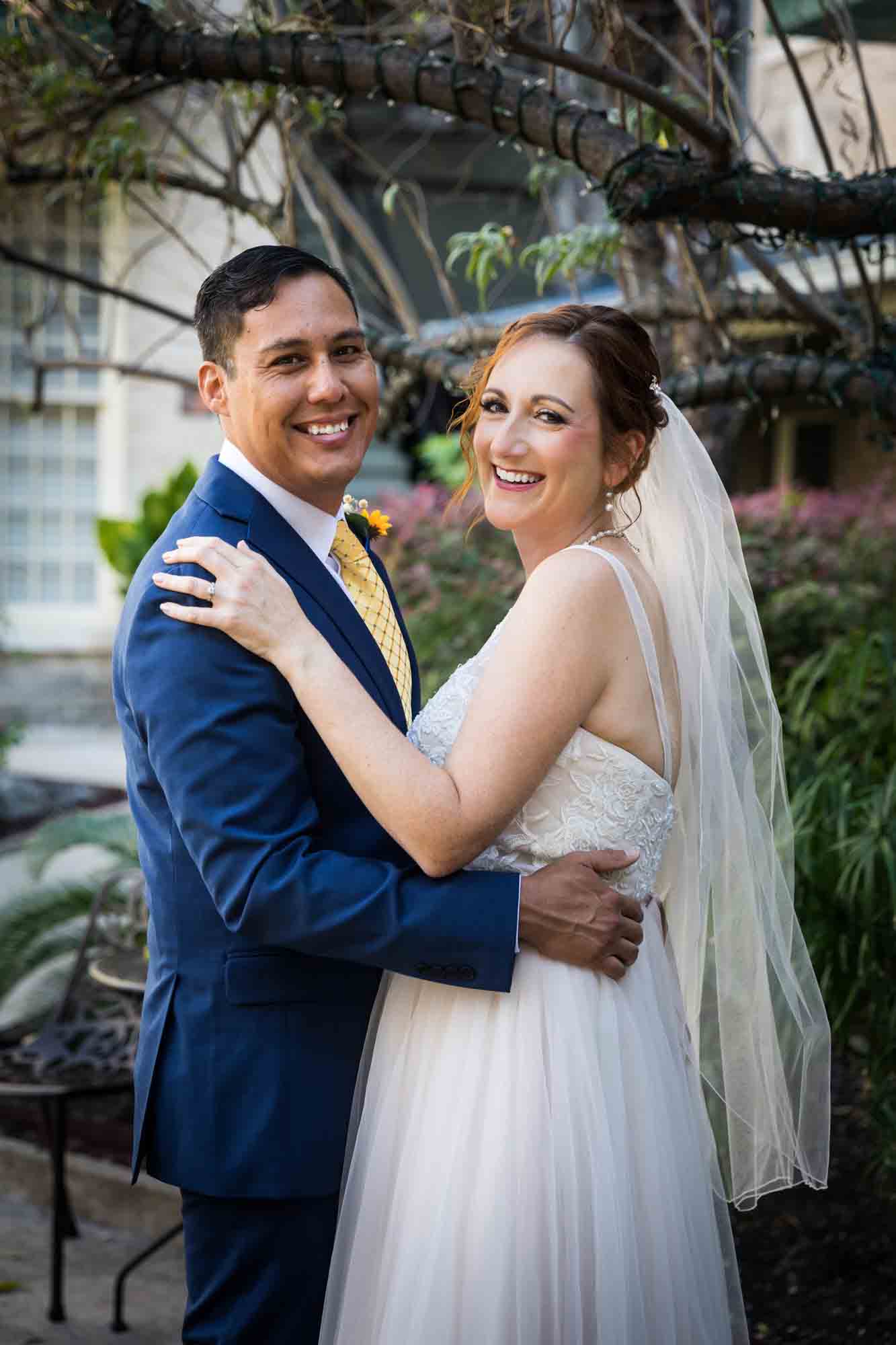 Bride and groom dancing in plant-filled courtyard at the Menger Hotel