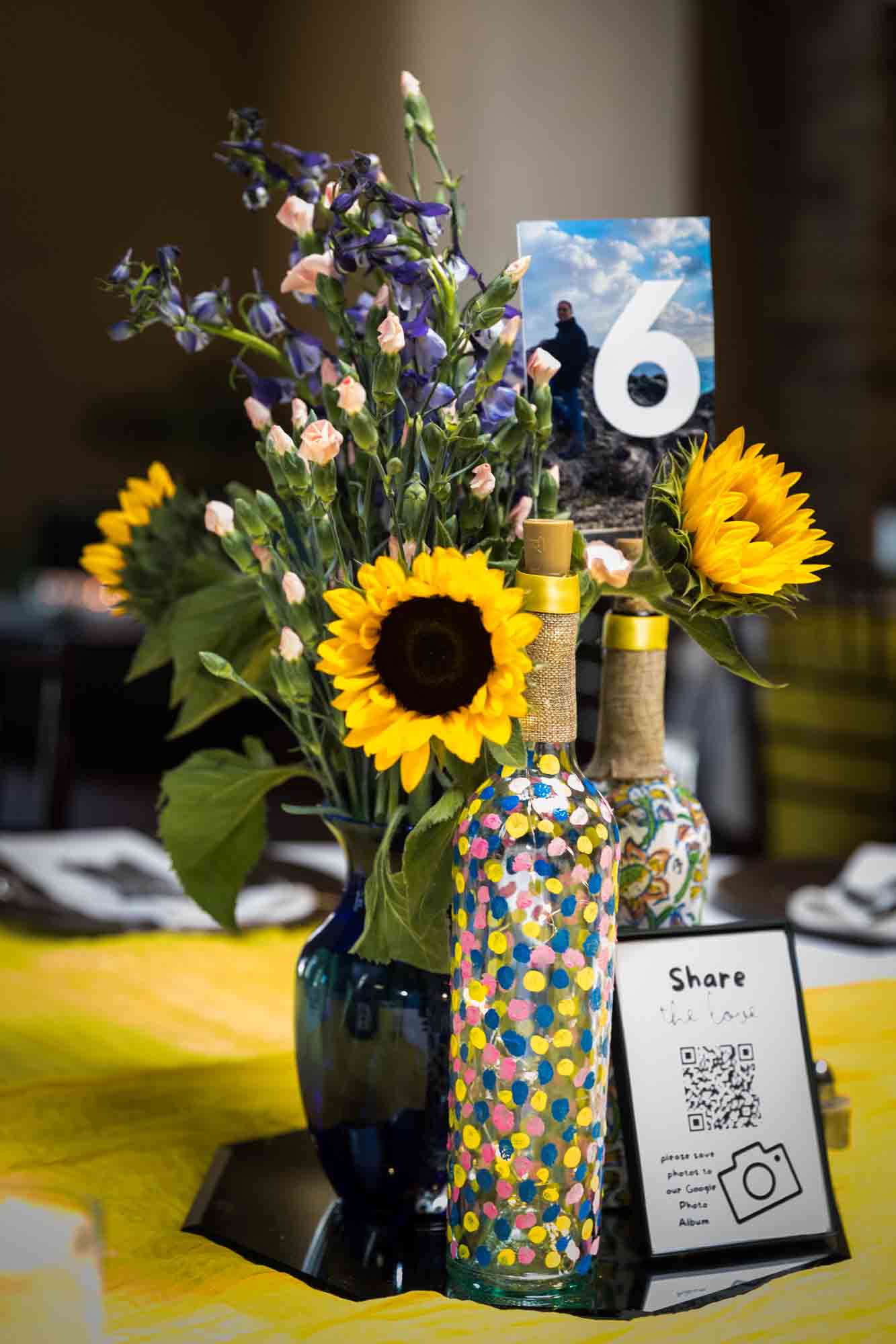 Colorful centerpiece with yellow sunflowers and painted glass bottles at a Pat O'Brien's wedding