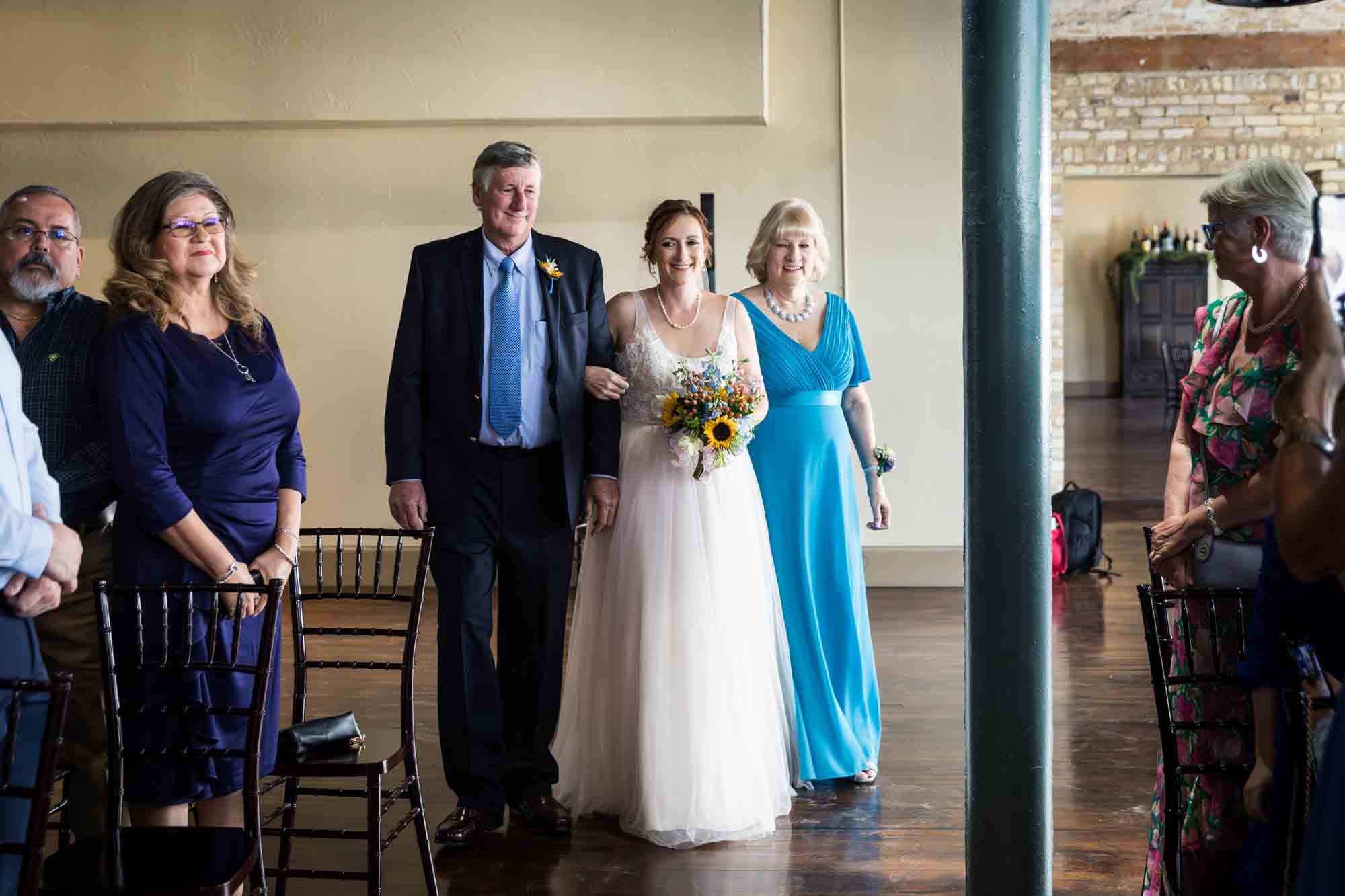 Pat O’Brien wedding photos of a bride escorted by mother and father down aisle