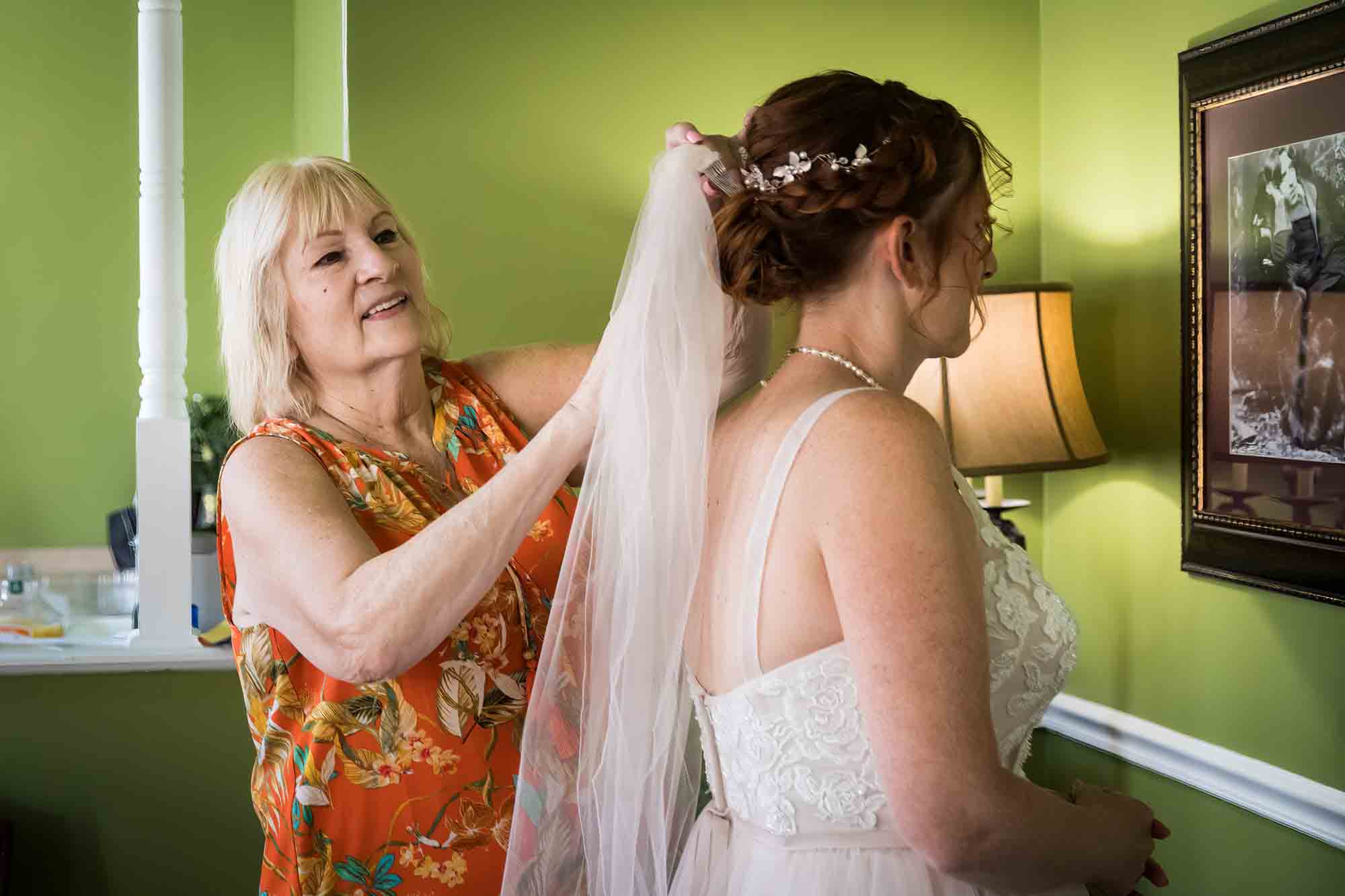 Mother inserting white veil into bride's hair at the Menger Hotel