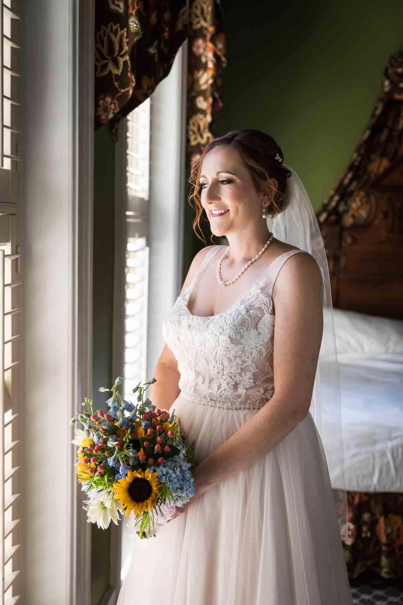 Bride holding bouquet of flowers in front of window at the Menger Hotel