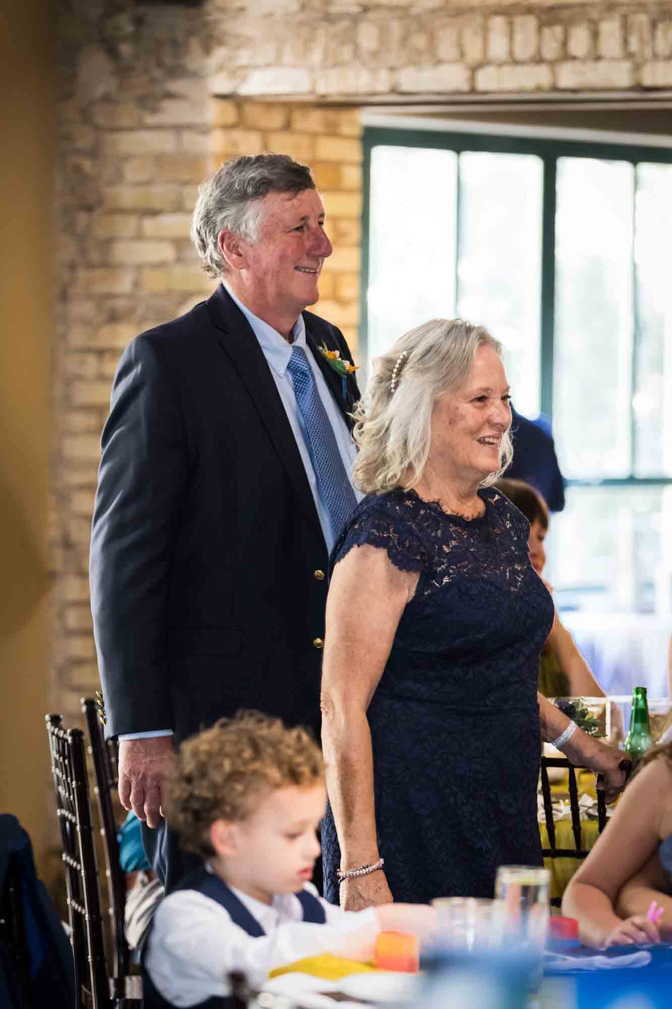 Pat O’Brien wedding photos of mother and father standing in front of window listening to speeches