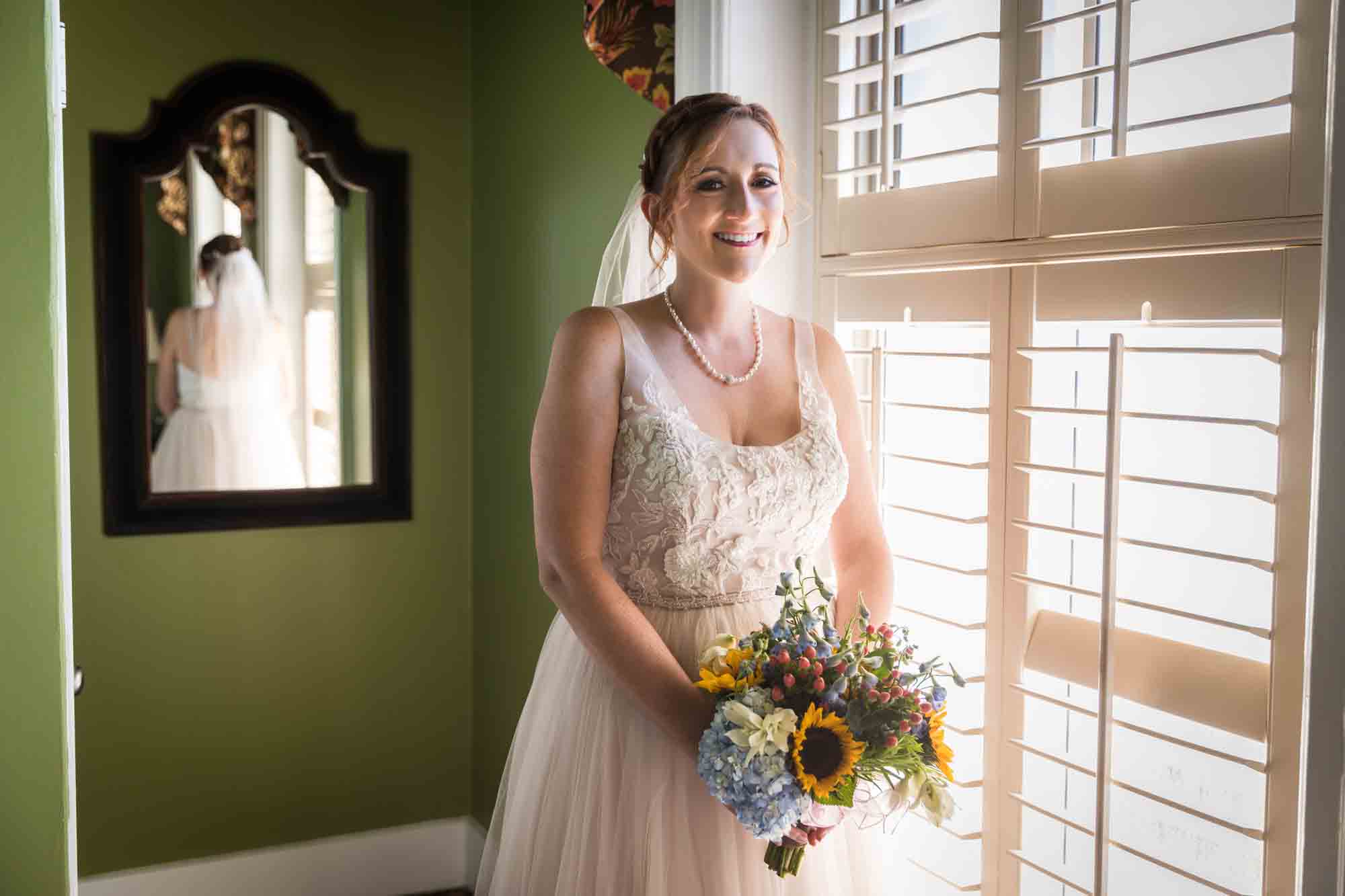 Bride holding bouquet of flowers in front of window at the Menger Hotel