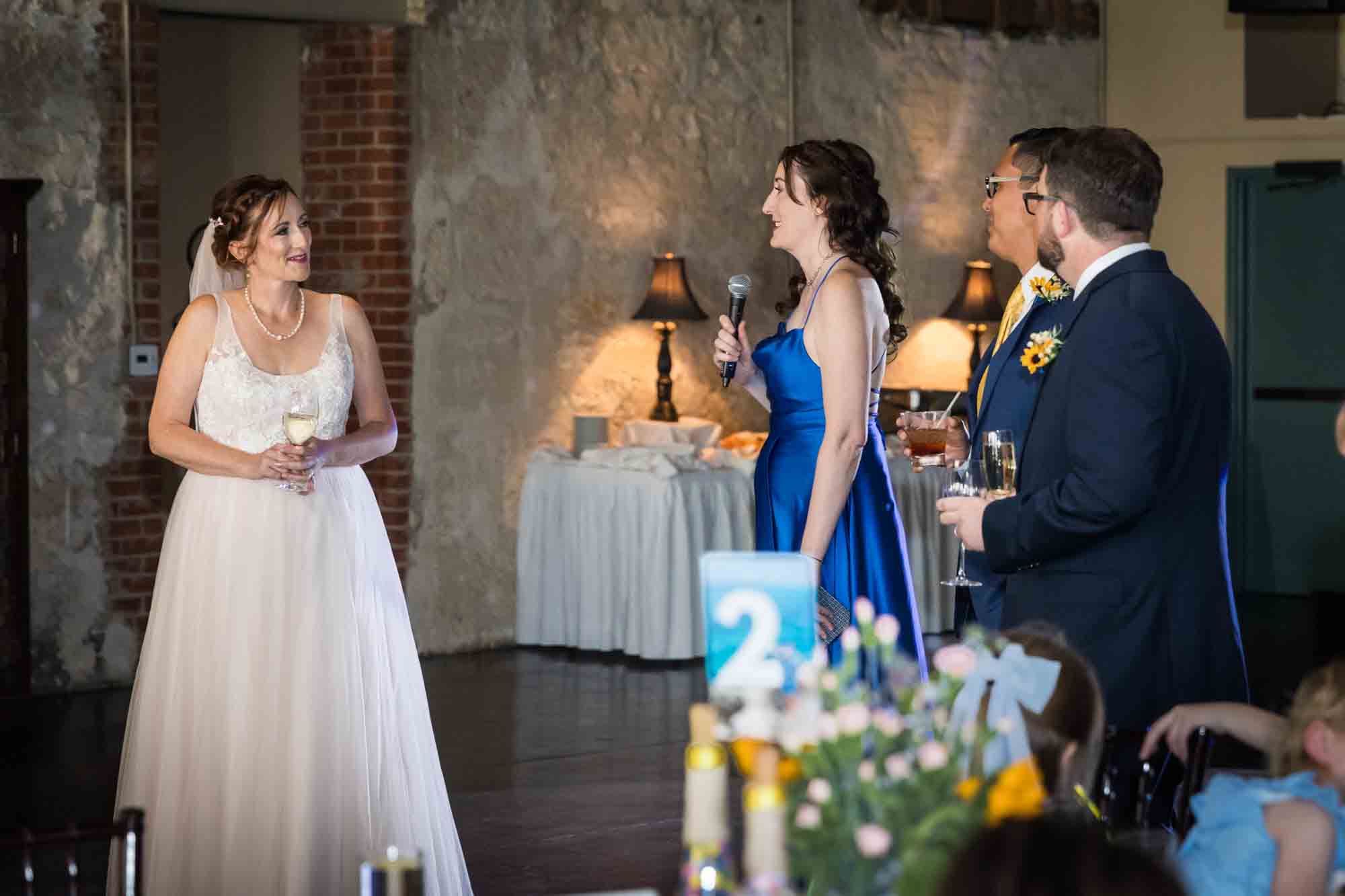 Pat O’Brien wedding photos of bridesmaid making speech to bride with groom and best man in background