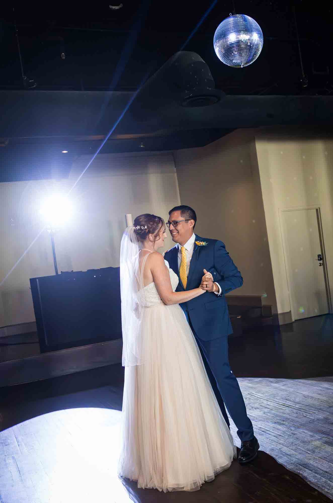 Pat O’Brien wedding photos of bride and groom during first dance with disco ball overhead