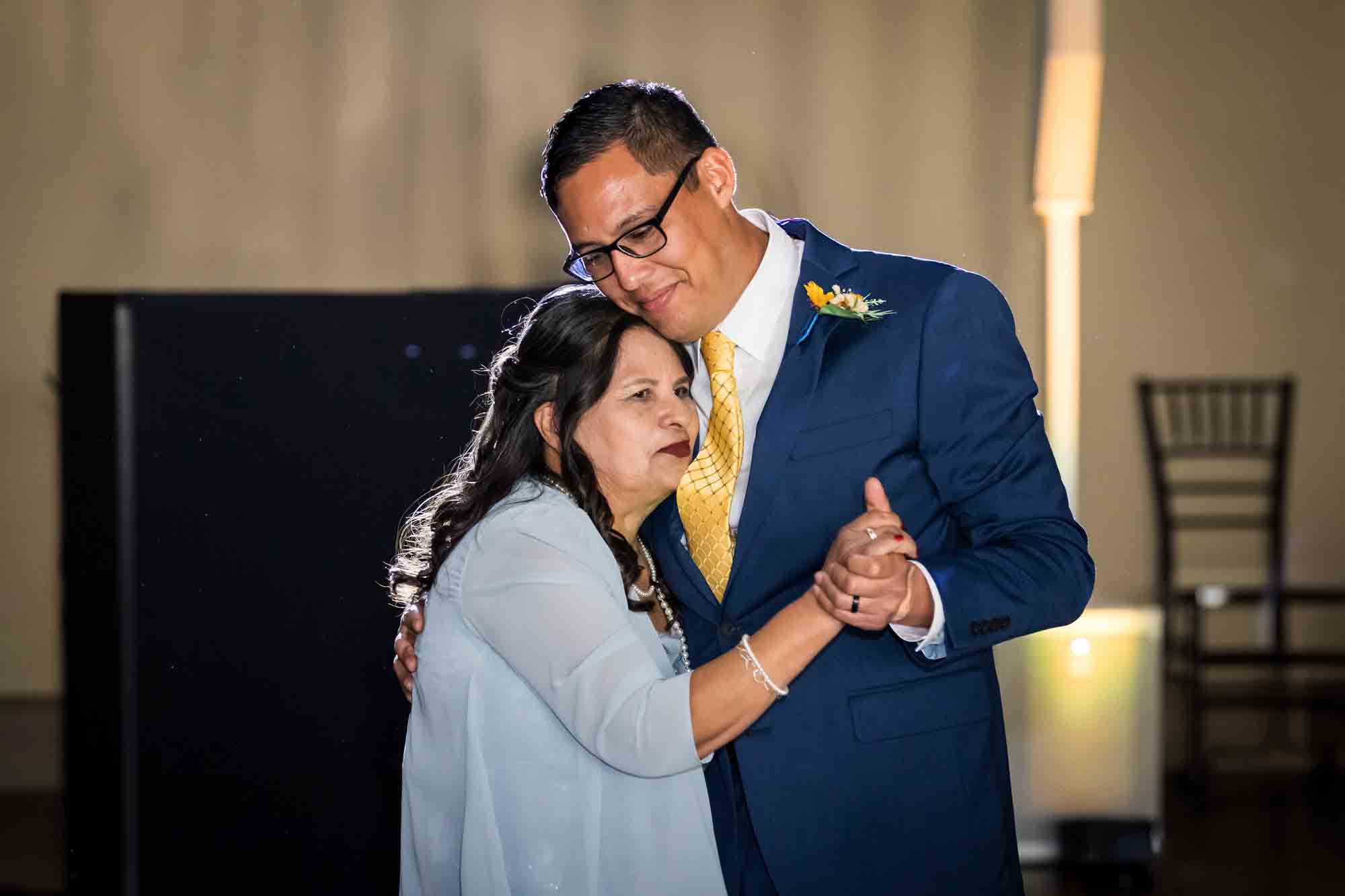 Pat O’Brien wedding photos of groom dancing with mother wearing light blue dress