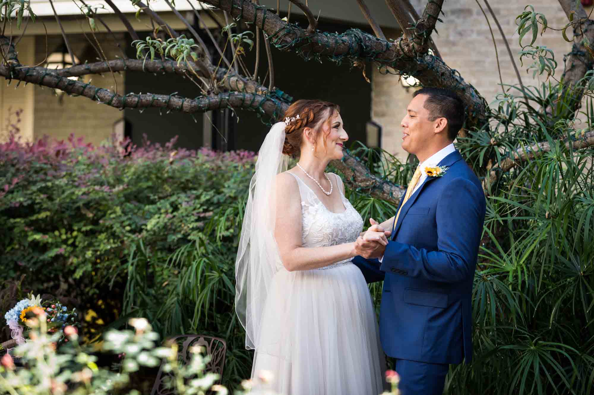 Bride and groom dancing in plant-filled courtyard at the Menger Hotel