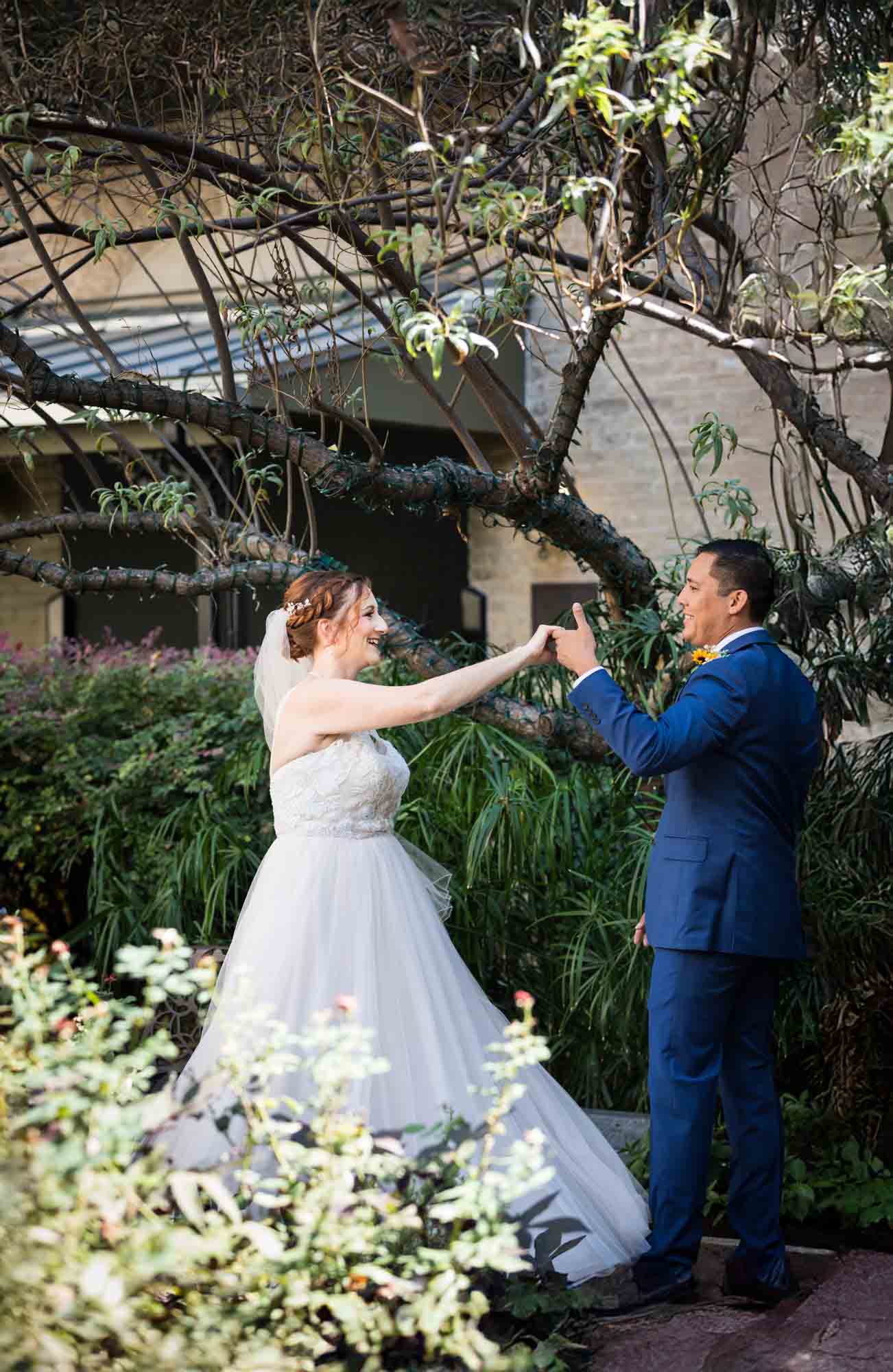 Bride and groom dancing in plant-filled courtyard at the Menger Hotel