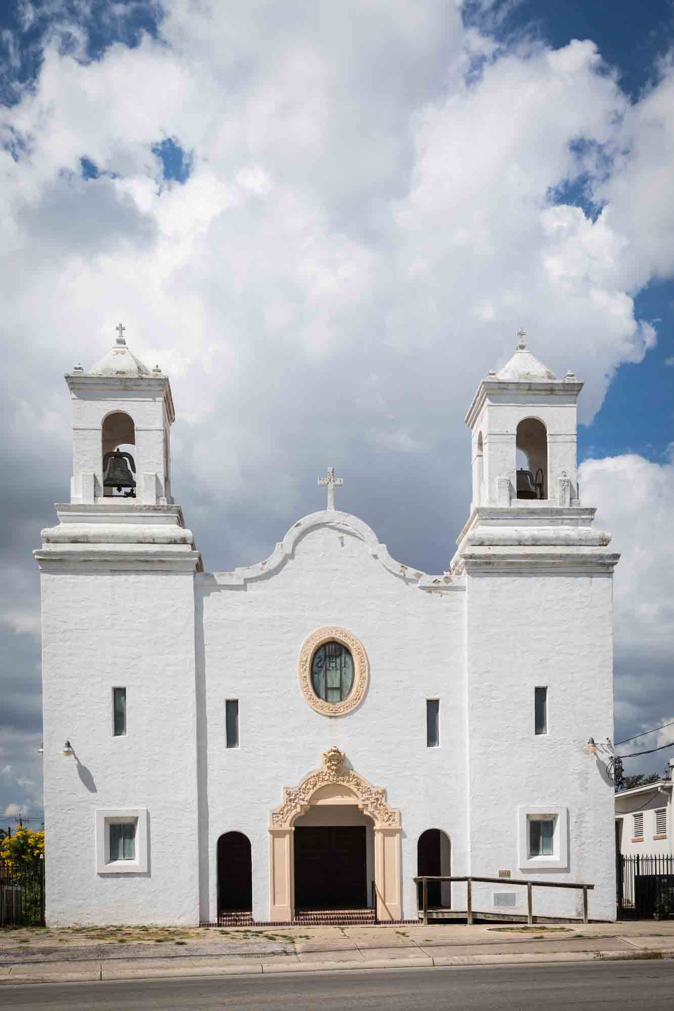 Wide shot of exterior of St. Henry Catholic Church in San Antonio with clouds above