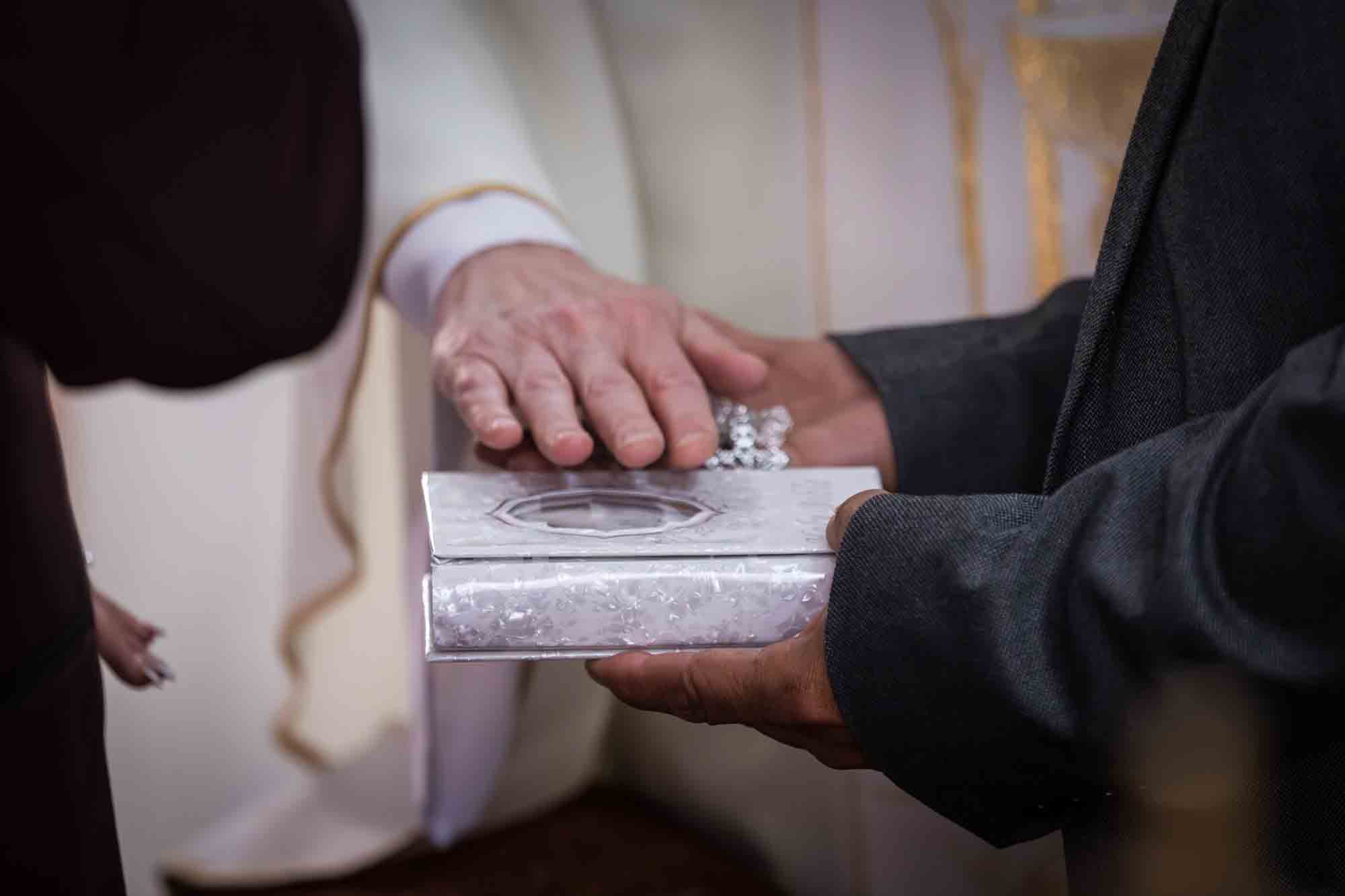 St. Henry Catholic Church wedding photos of priest's hand over silver bible and rosary