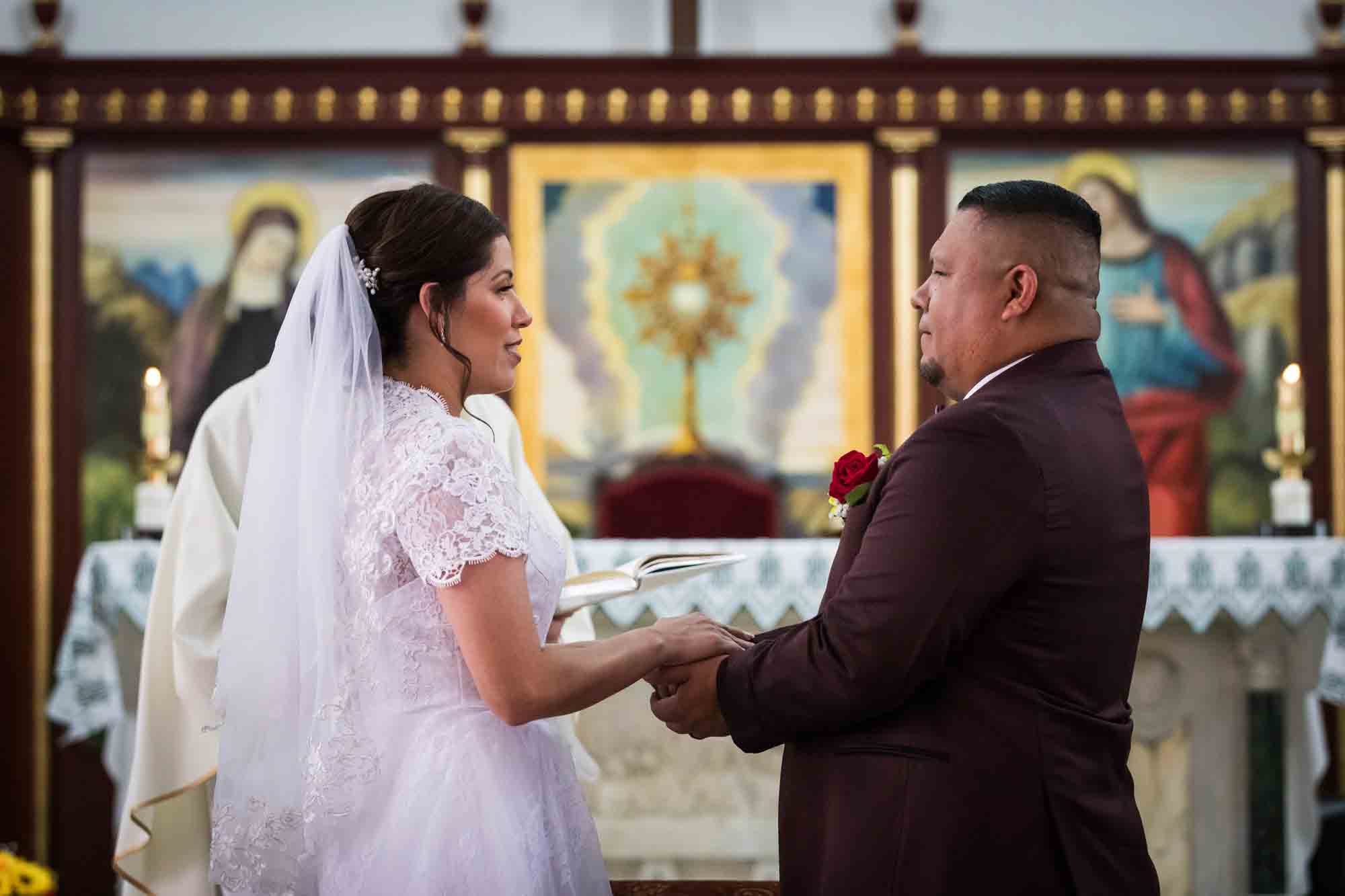 St. Henry Catholic Church wedding photos of bride and groom exchanging dimes during ceremony