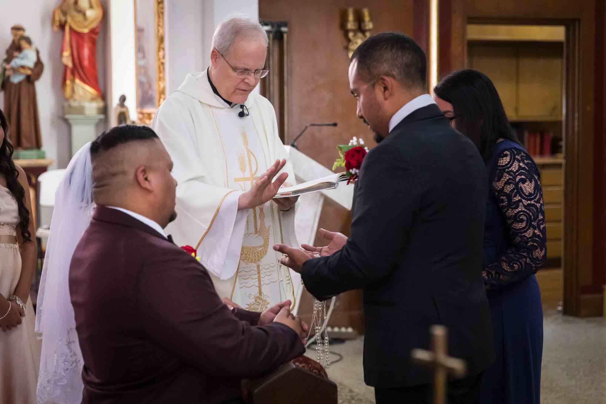 St. Henry Catholic Church wedding photos of lasso being blessed by priest