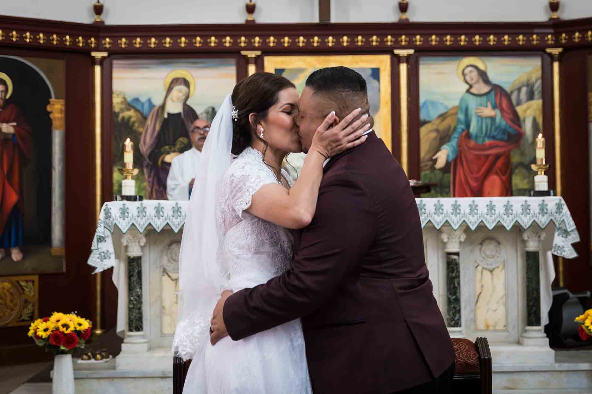 St. Henry Catholic Church wedding photos of kissing in front of altar