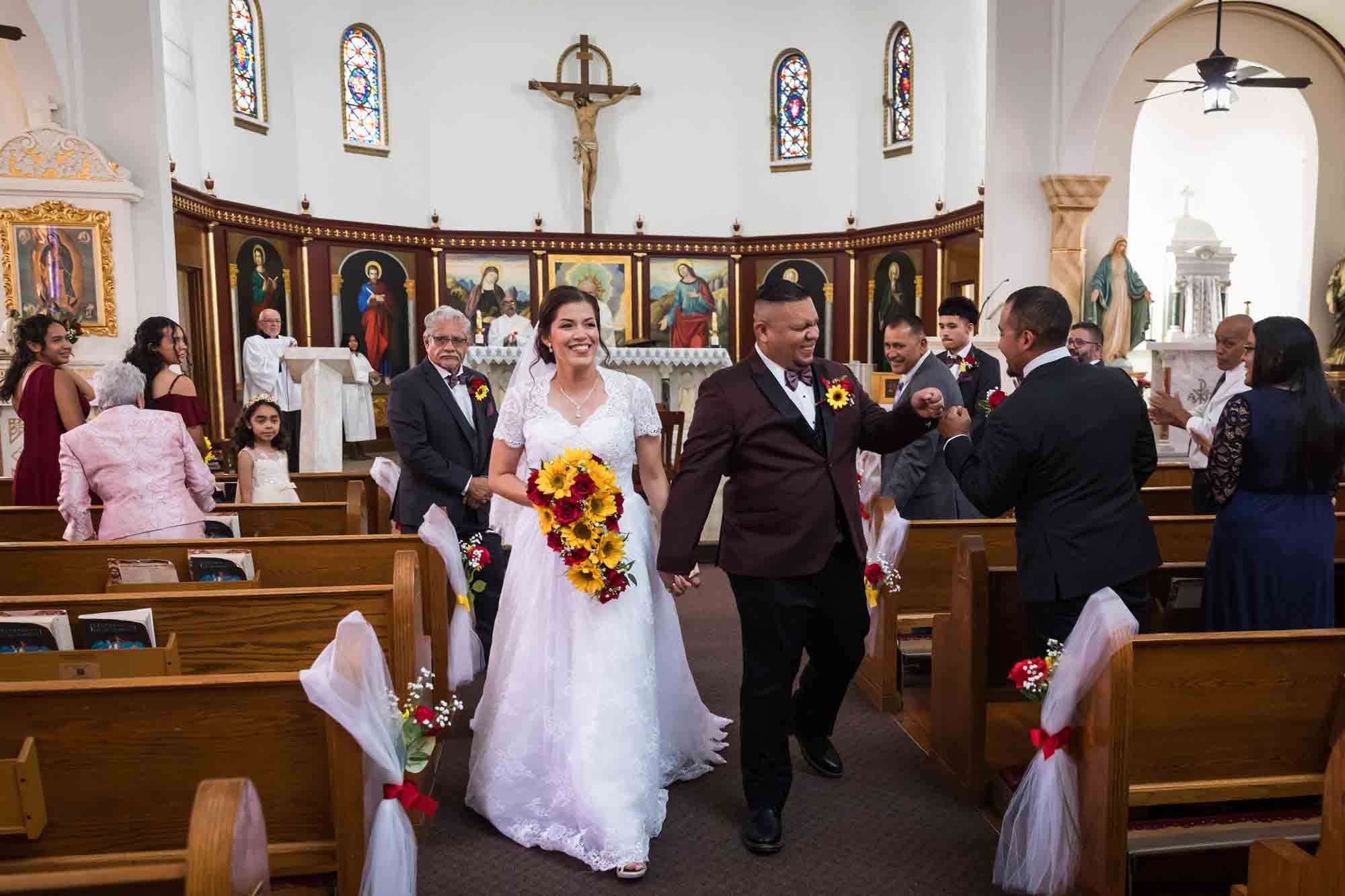 St. Henry Catholic Church wedding photos of bride and groom walking down aisle and greeting guests after ceremony