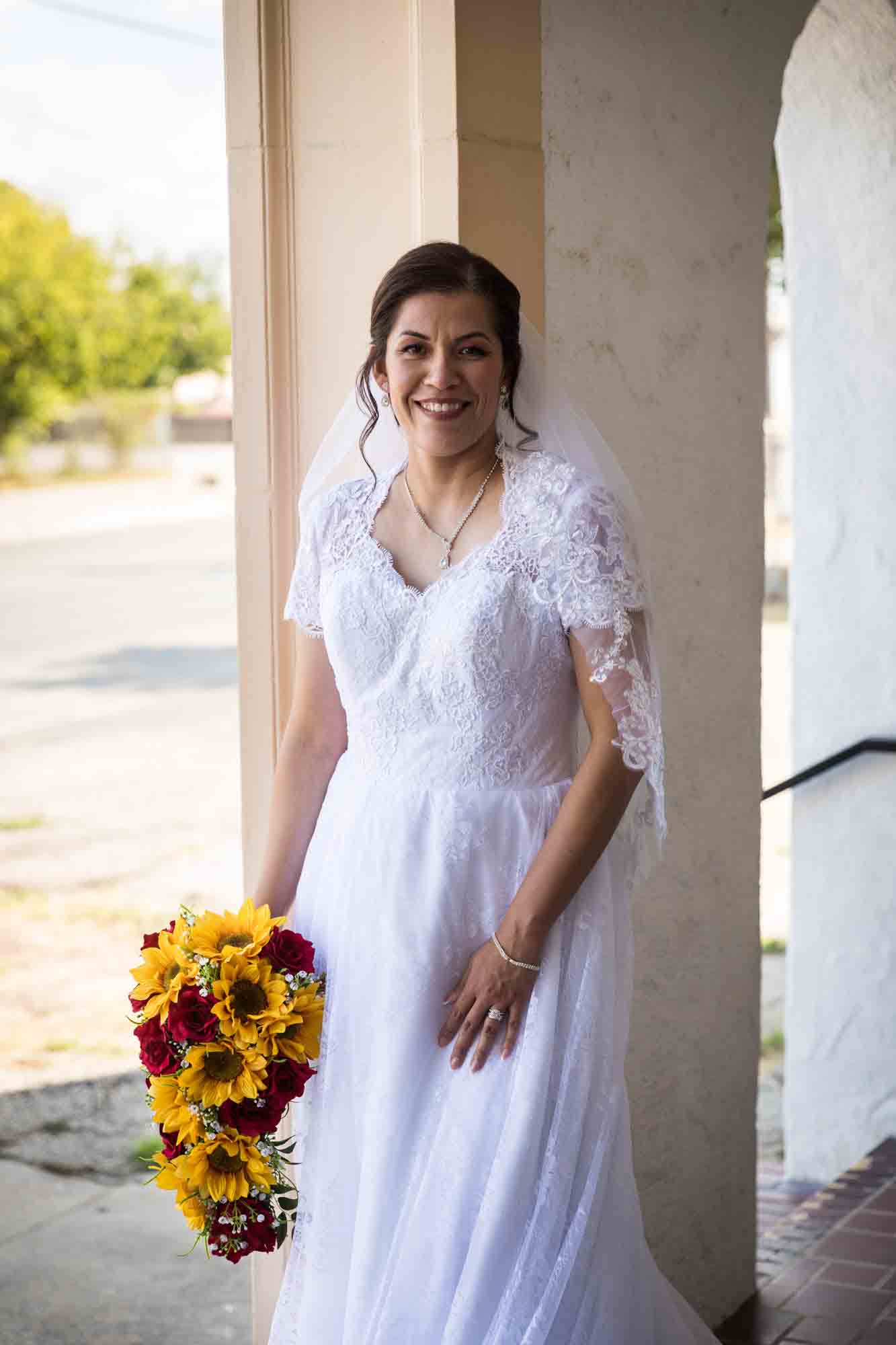 St. Henry Catholic Church wedding photos of bride holding bouquet of sunflowers and red roses in entrance to church