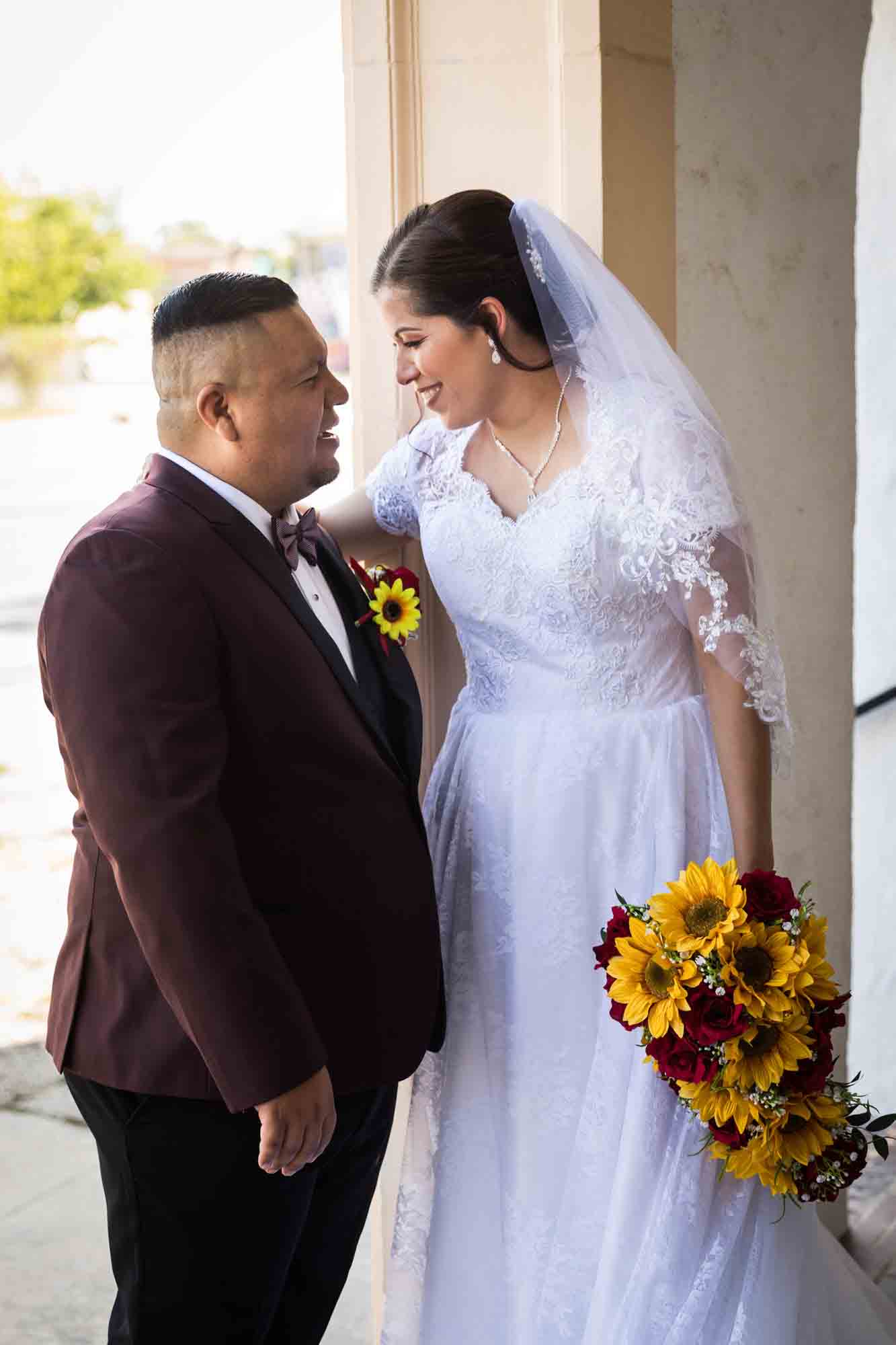 St. Henry Catholic Church wedding photos of bride and groom laughing at each other in entrance to church