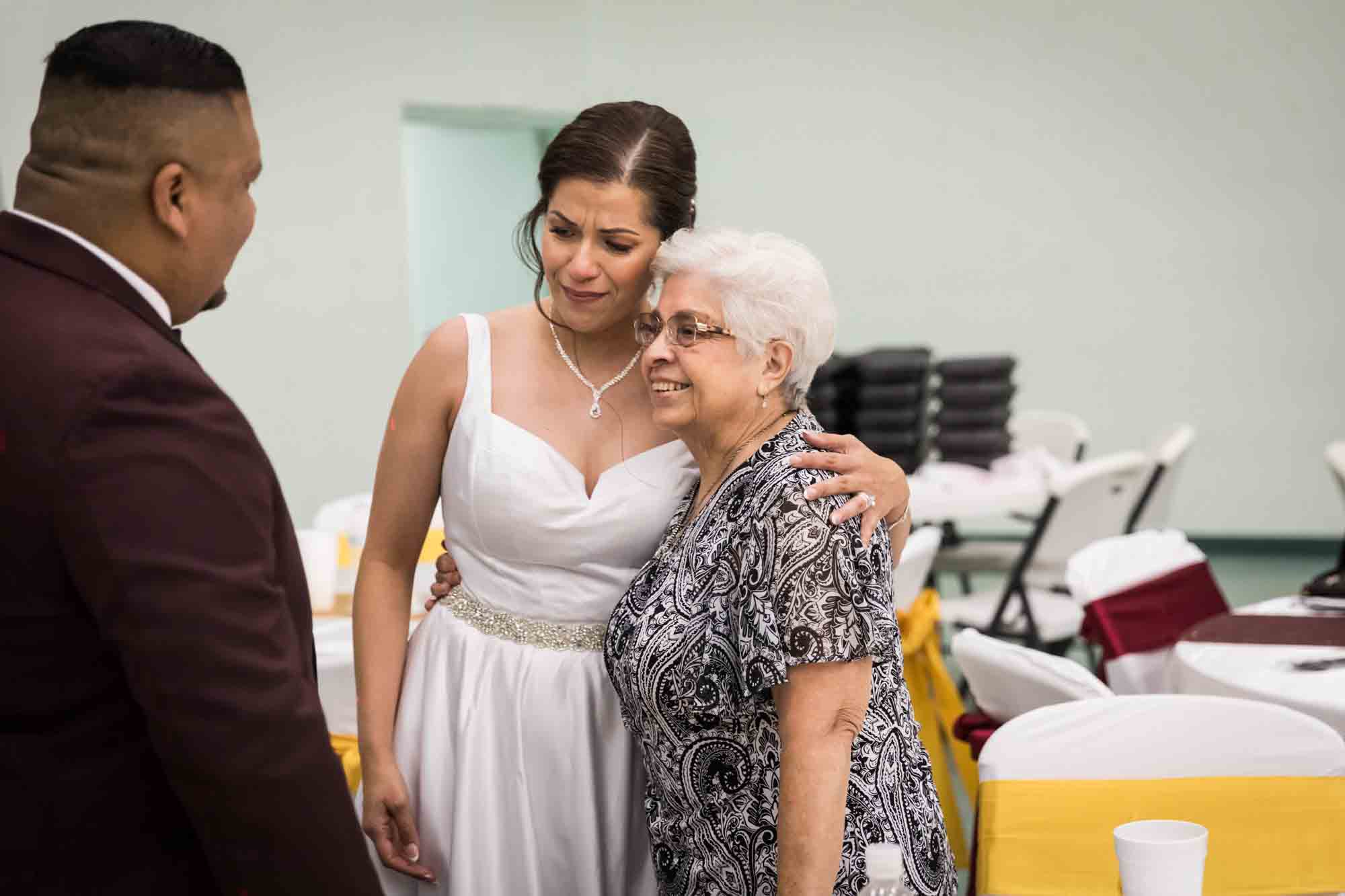 Bride hugging woman with short, white hair during a St. Henry Catholic Church wedding reception