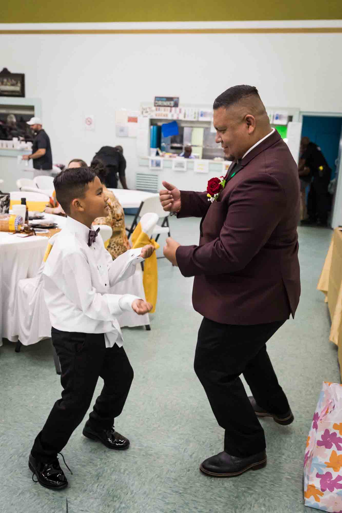 Groom and young son dancing during a St. Henry Catholic Church wedding reception