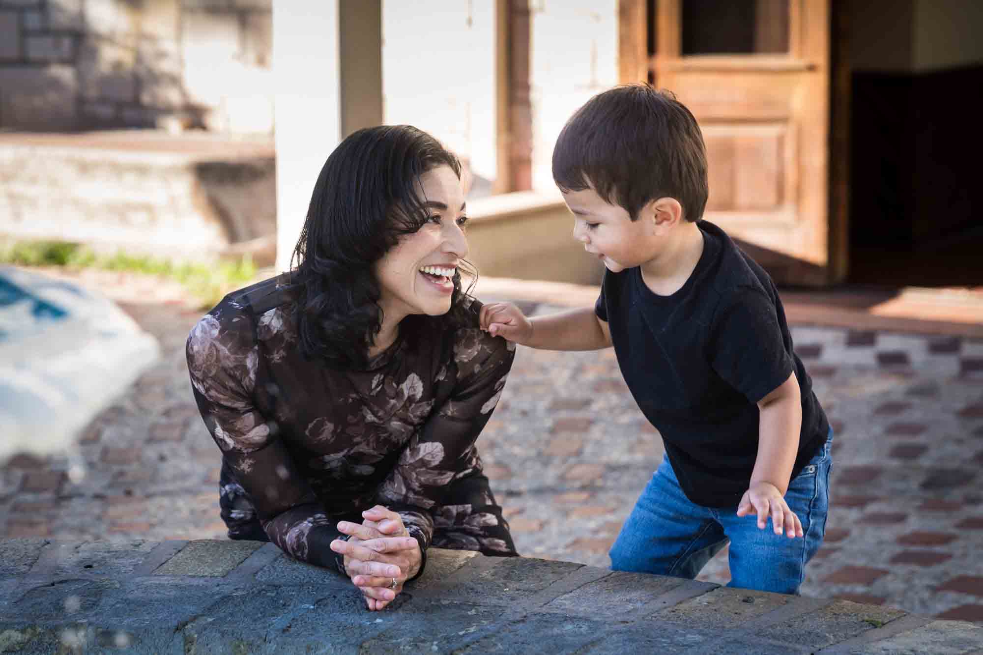 Mother smiling at little boy with cobblestone patio in background at La Villita